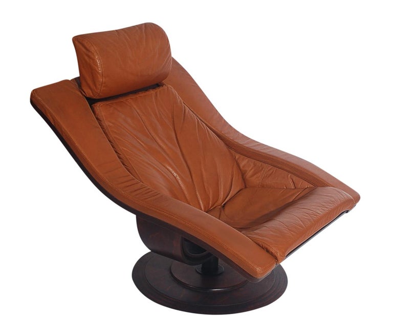Nelo Sweden swivel lounge chair by Takashi Okamura & Erik Marquardsen, in cognac leather with matching ottoman. Heavy well-made set with rosewood stained wood bases. Price includes the set. Ottoman measures 21