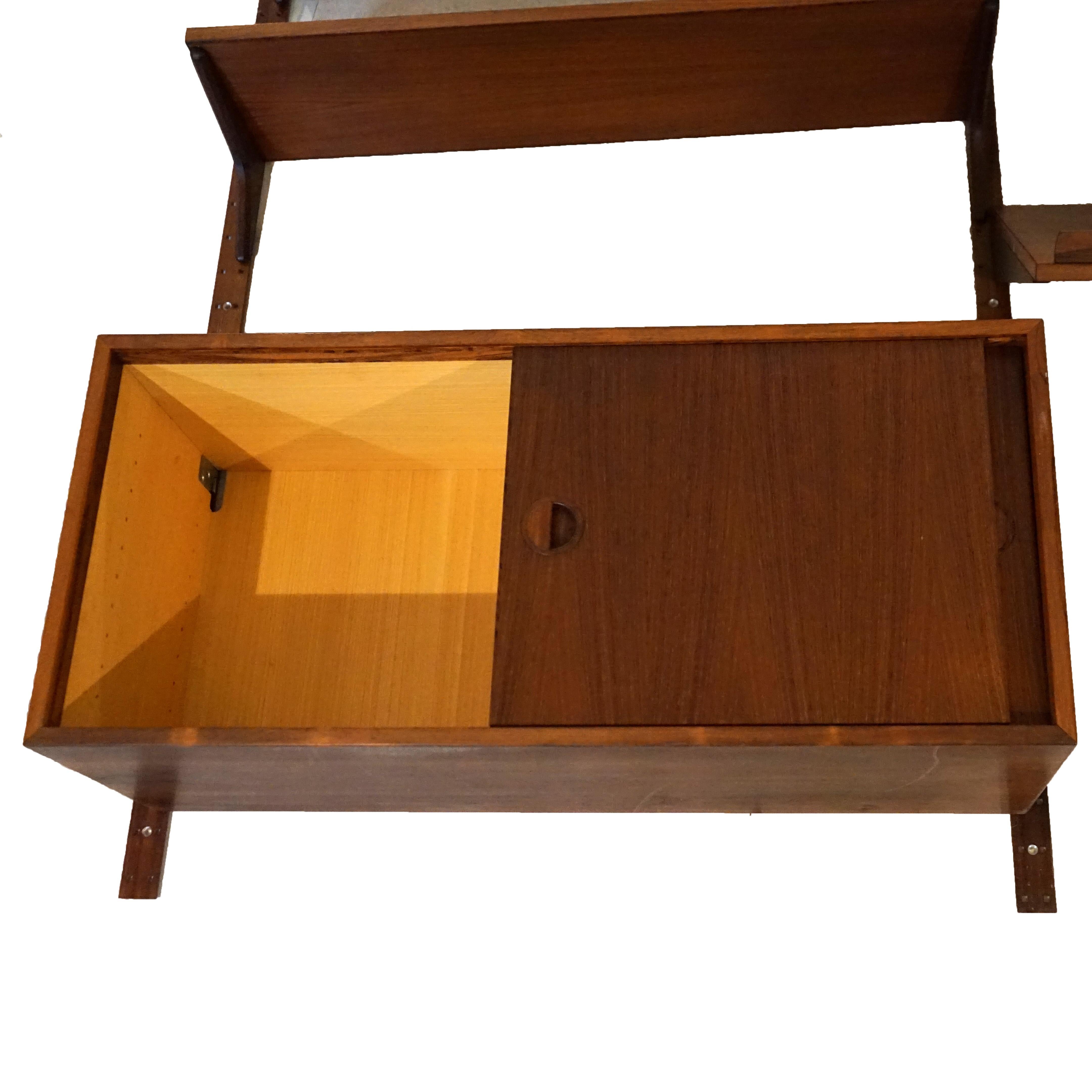 A Mid Century Danish Modern modular wall unit offers rosewood components including cabinet with tambour doors, traditional double door cabinet, writing desk, and shelves, c1950

Measures- Overall 78.5''H x 35.25''W x 16''D; Small Cabinet 16.5''H x