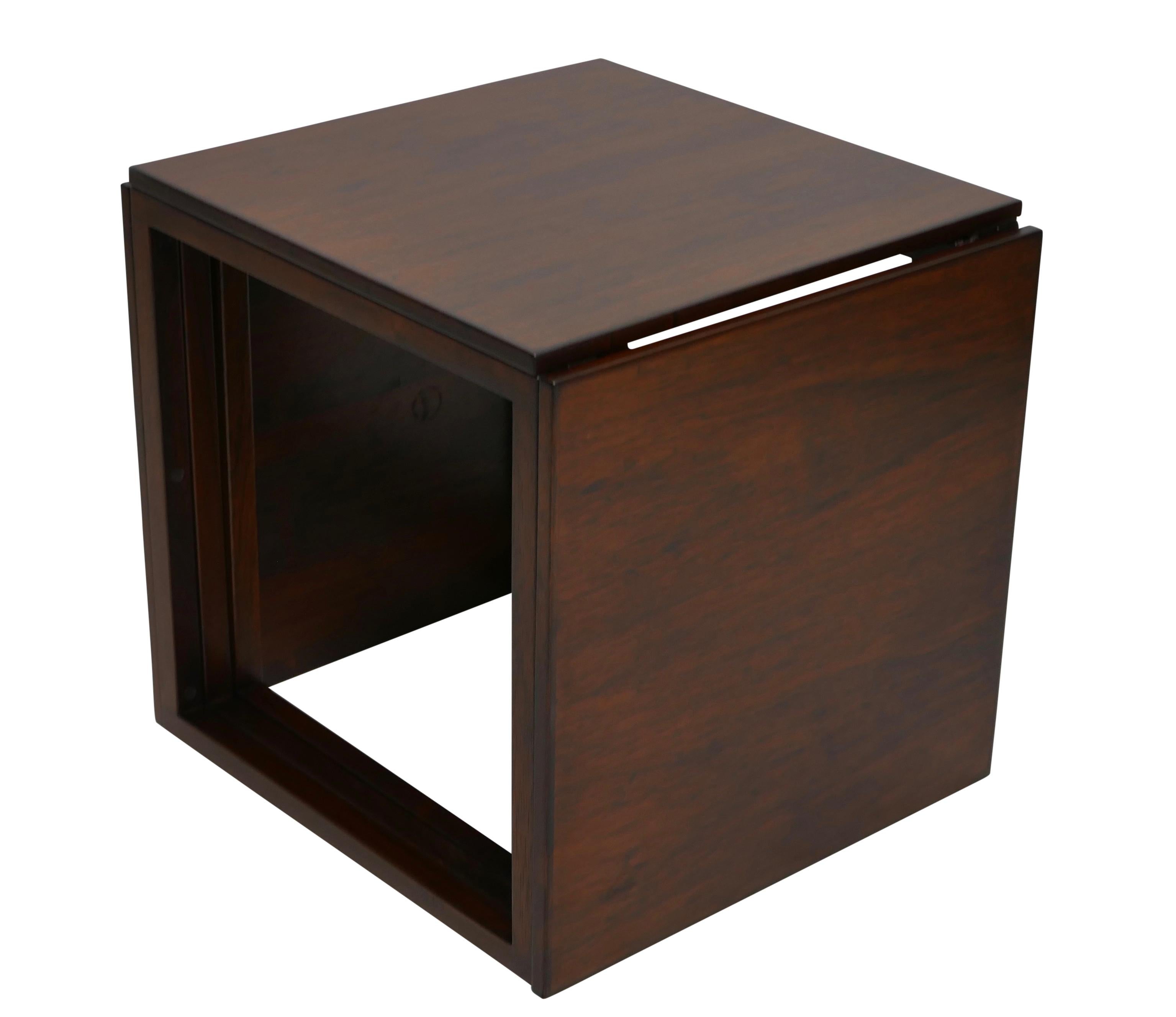 A unique set of three rosewood nesting tables, they nest to form a cube with two solid sides and two open sides. Marked on the underside Made in Denmark. Danish, mid-20th century.
 