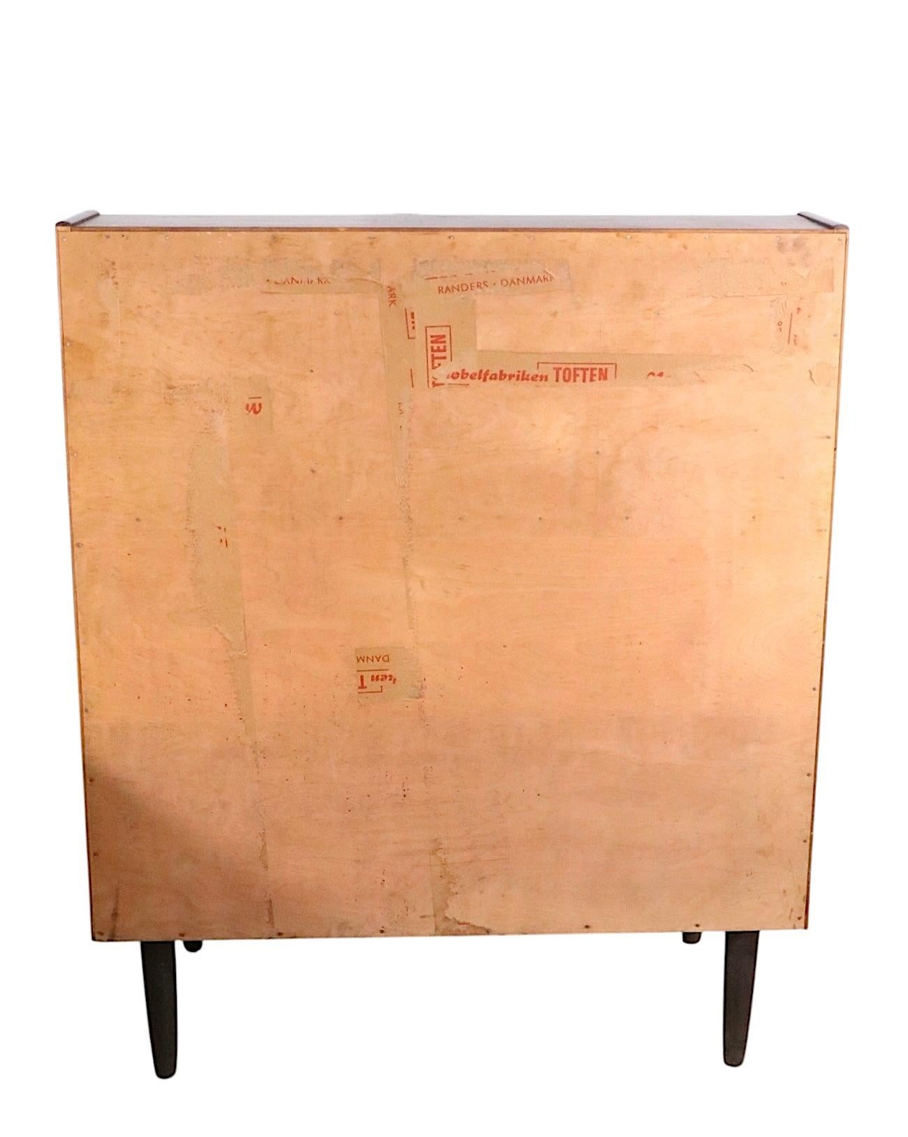 Stunning Mid Century Danish Modern secretary desk, executed in vibrant rosewood veneer. This exceptional piece features a lower section which has three deep drawers, over which is a flat writing surface, two banks of three drawers, flanking an open