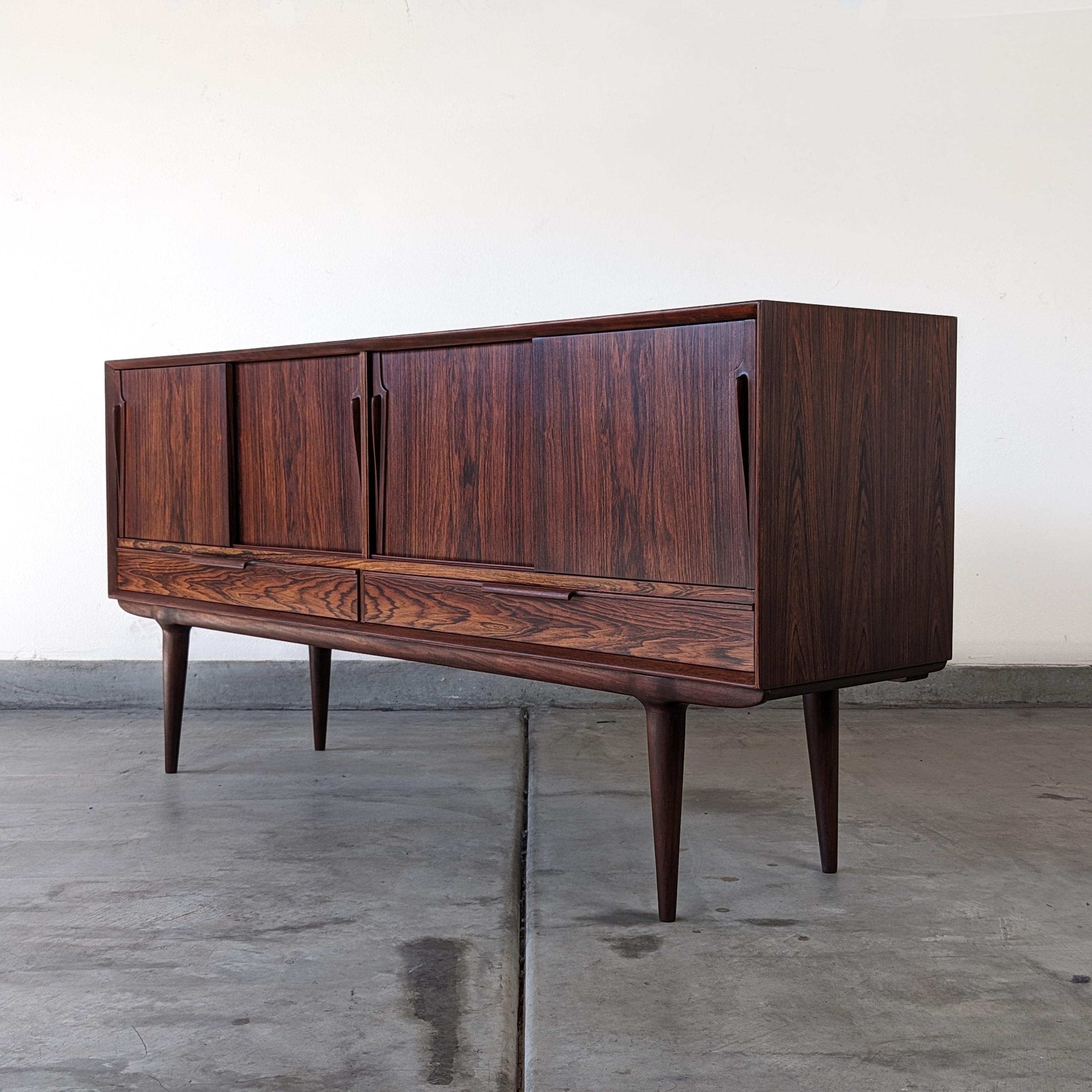 Immerse yourself in the timeless elegance of a mid-century marvel with this exquisite Danish sideboard, a testament to the masterful craftsmanship of Gunni Omann for the esteemed Omann Jun Mobelfabrik. Designed in the 1960s, this sideboard boasts a