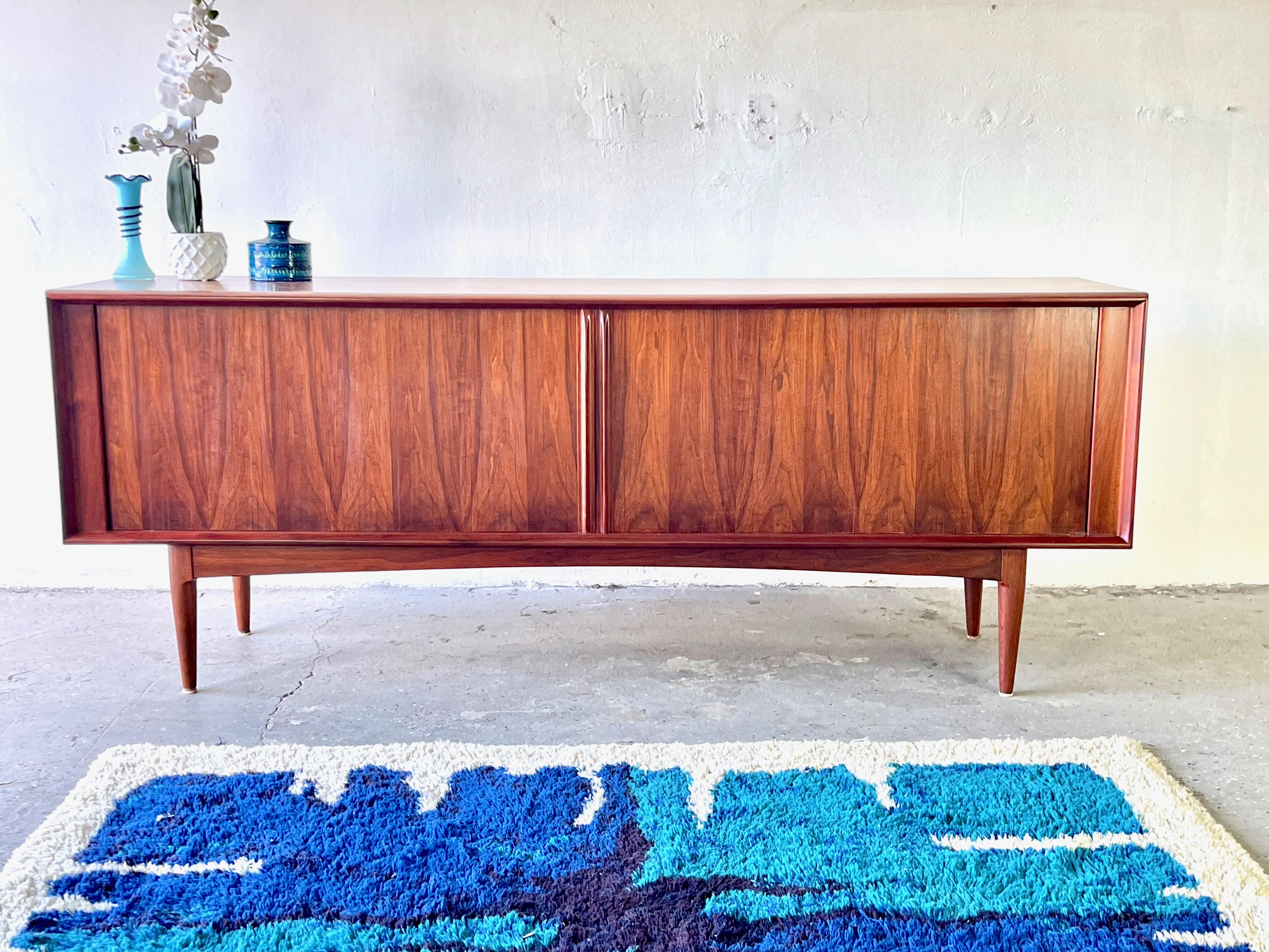 Mid century Danish Modern Rosewood Tambour doors credenza

Rich, highly figured rosewood is the perfect canvas for this sleek, Scandinavian design. This Bernhard Pedersen & Sons is stunning in its simplicity, it features streamlined tambour doors