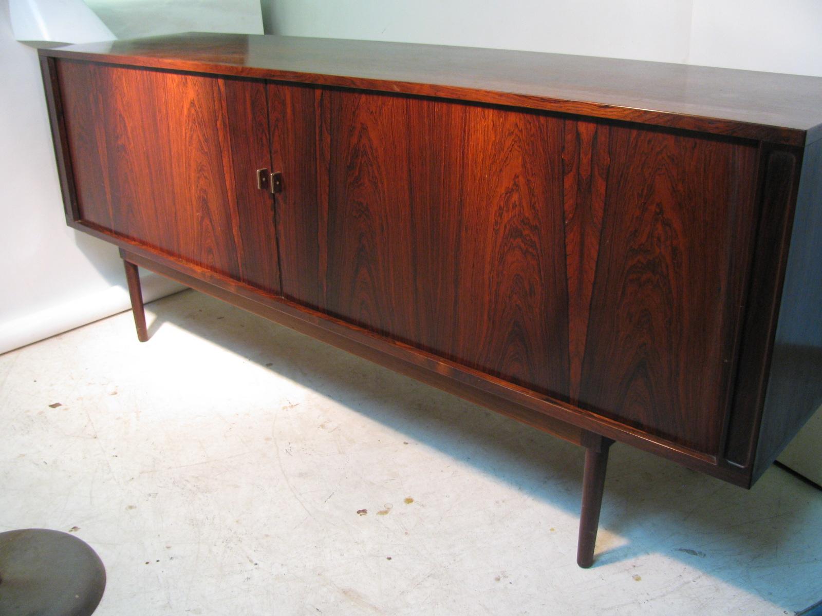 Stunning and sexy Danish rosewood credenza by Peter Lovig Nielsen. Dated 1967 on the underside. Simple and so elegant in its design. Tambour doors with dovetail construction glide open to reveal 5 center drawers for flatware and such. Total 3