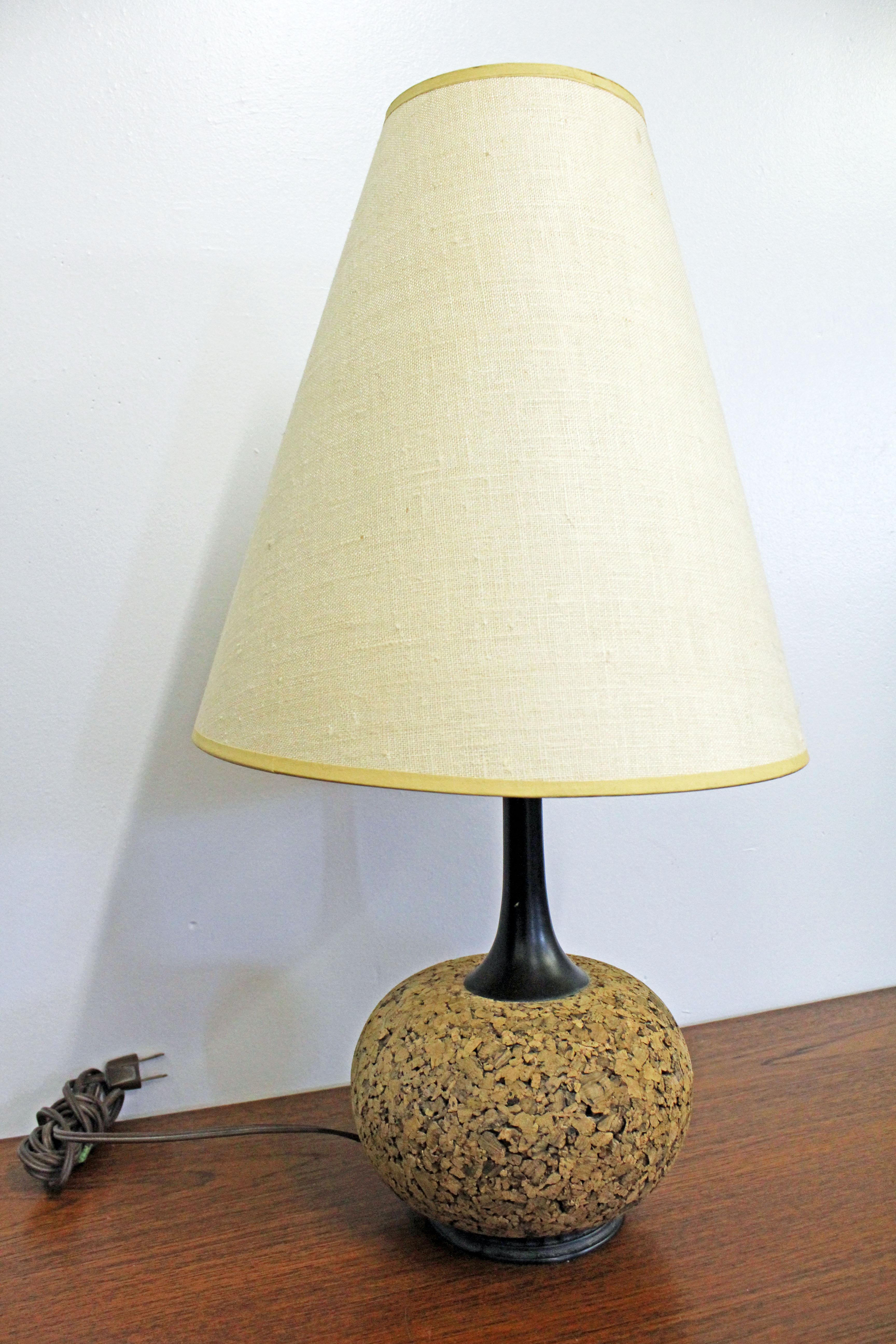 Offered is a Mid-Century Modern table lamp with a cork and metal base. It is in good, working condition showing slight age wear and small scratch on base. See pics for details. The shade is not included. It is not signed. A great piece to add to any