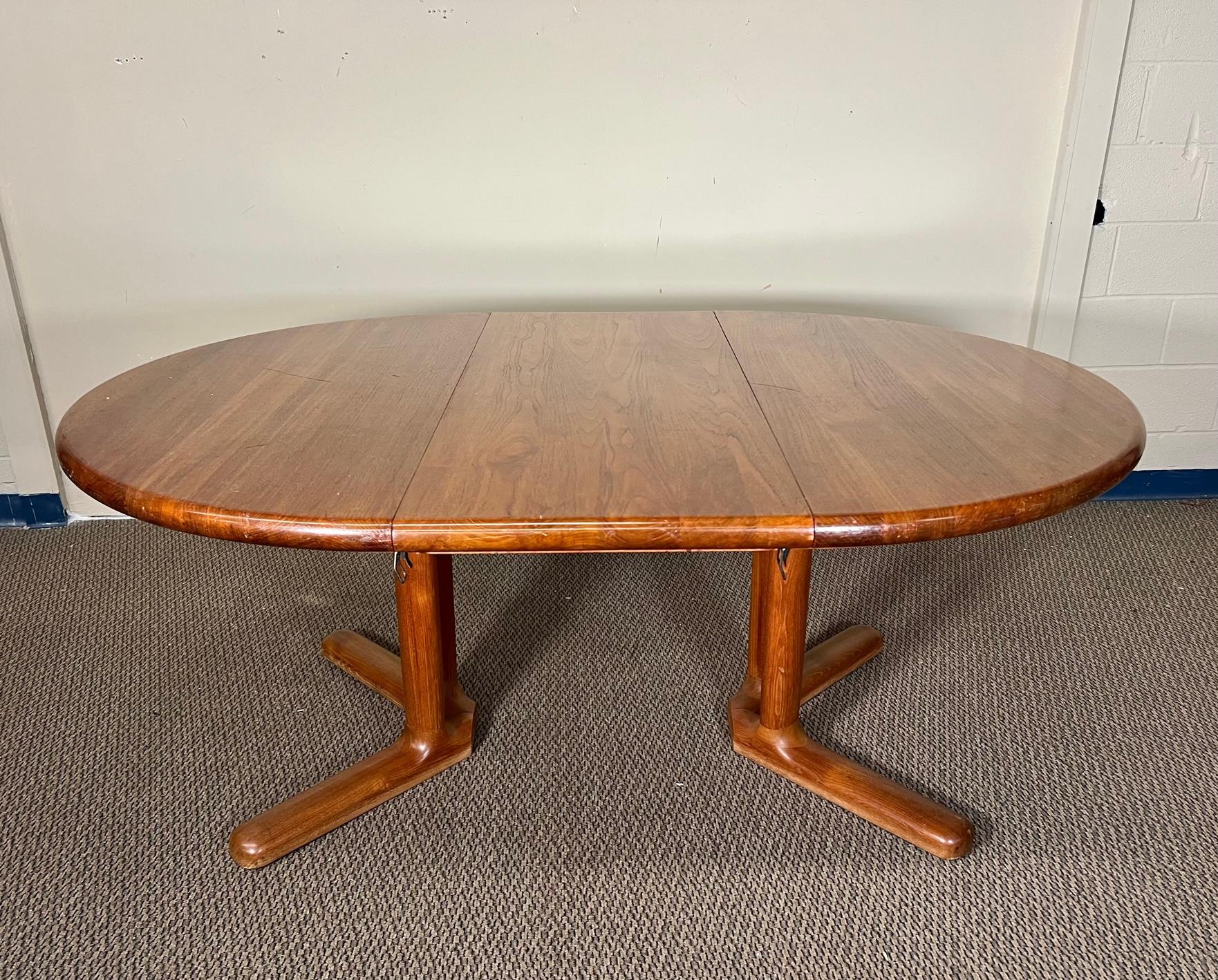This is a round Danish teak dining table with 1 extension leaf. It originally may have had 2 extension leaves but came to us with only one. Very nice condition overall. Some scratches on the top and gouges on the side. Dimensions: 48.5