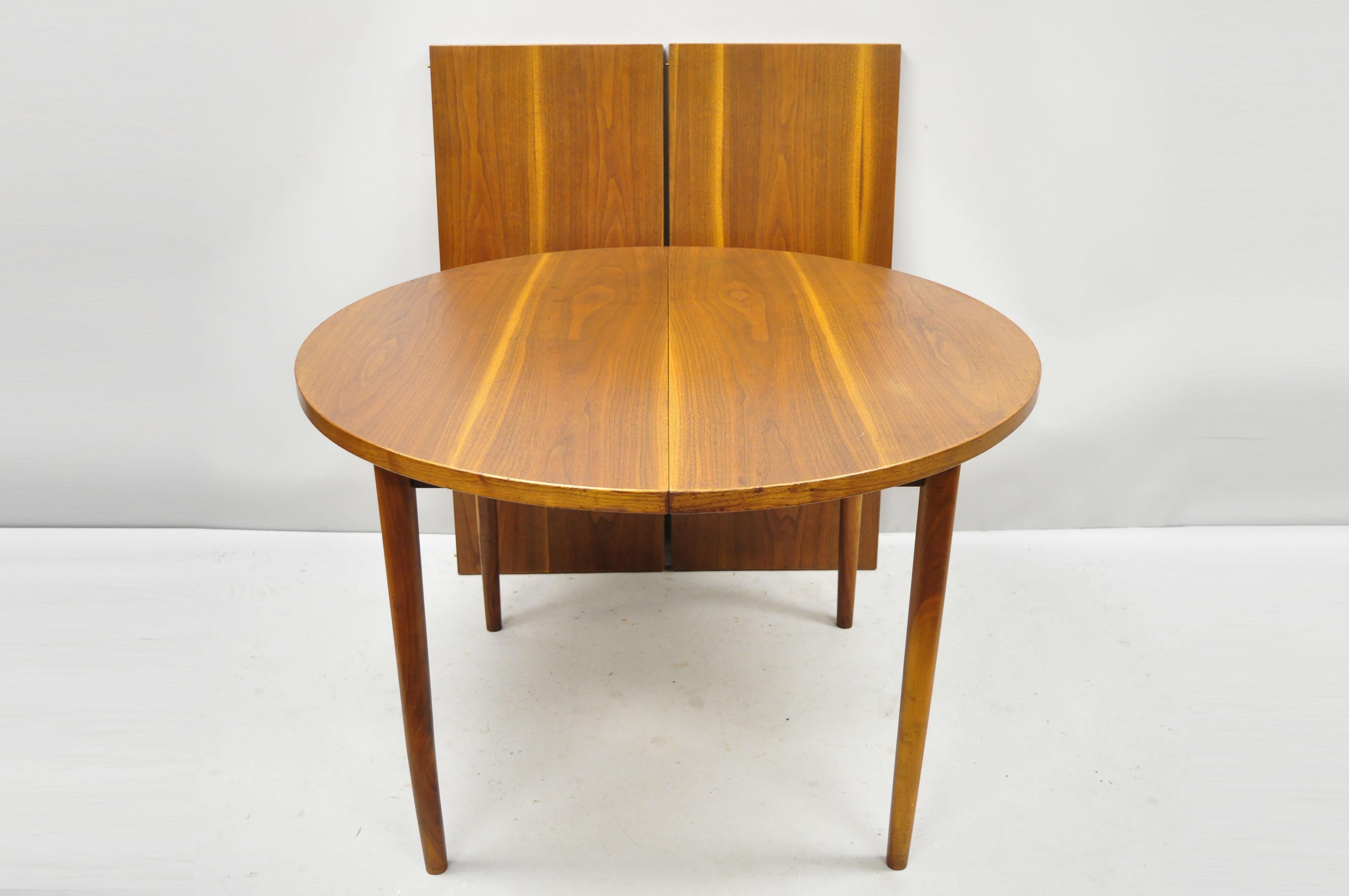 Midcentury Danish modern round teak wood dining room table with two leaves. Item features (2) 17.75