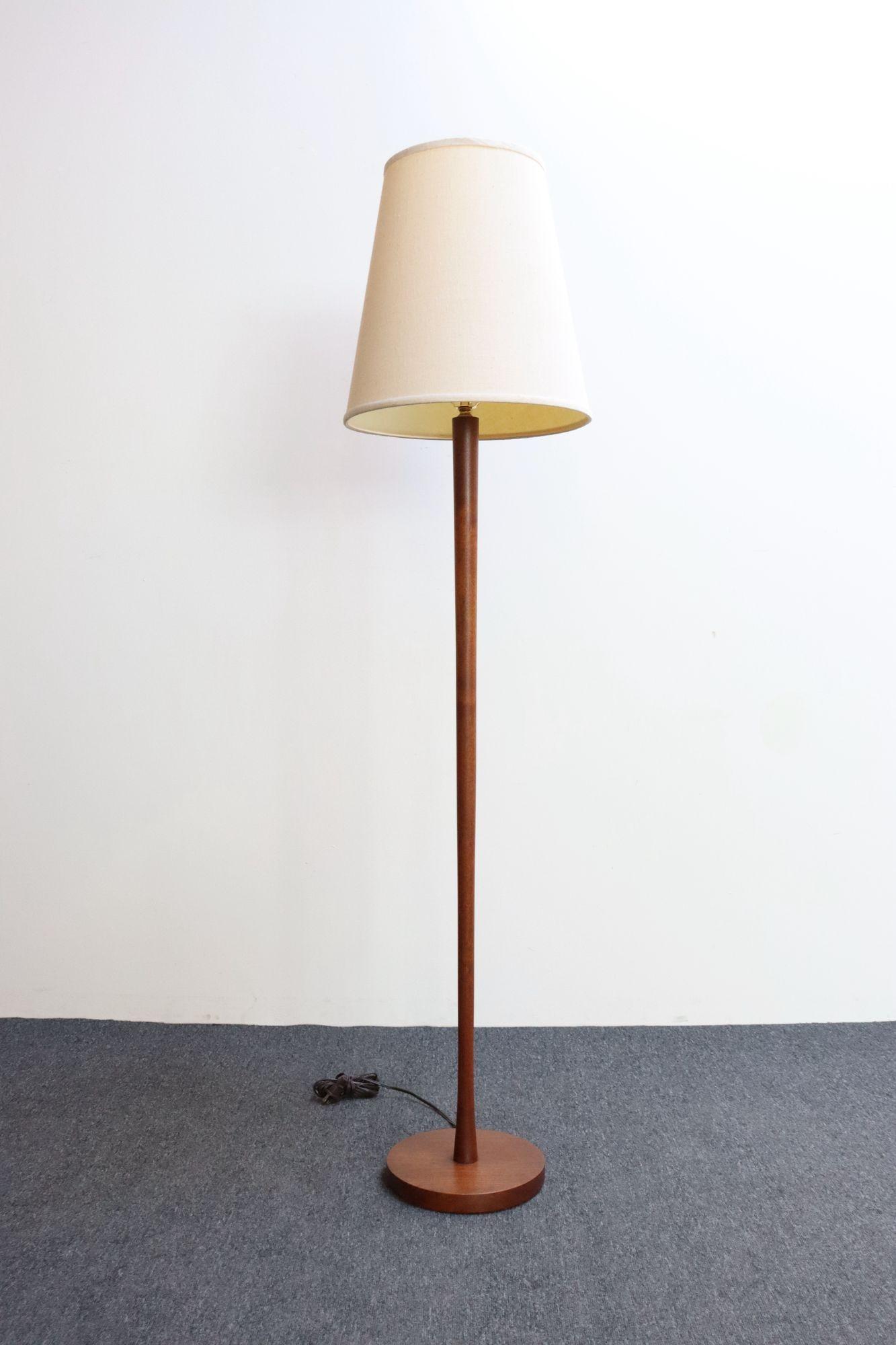 Sencilla y elegante lámpara de pie esculpida en madera maciza de teca, con tallo esbelto, cilíndrico y cónico, apoyado en una densa base redonda (ca. 1960, Dinamarca).
Vetas vivas y rico color de la teca, recién barnizado con un ligero desgaste.
La