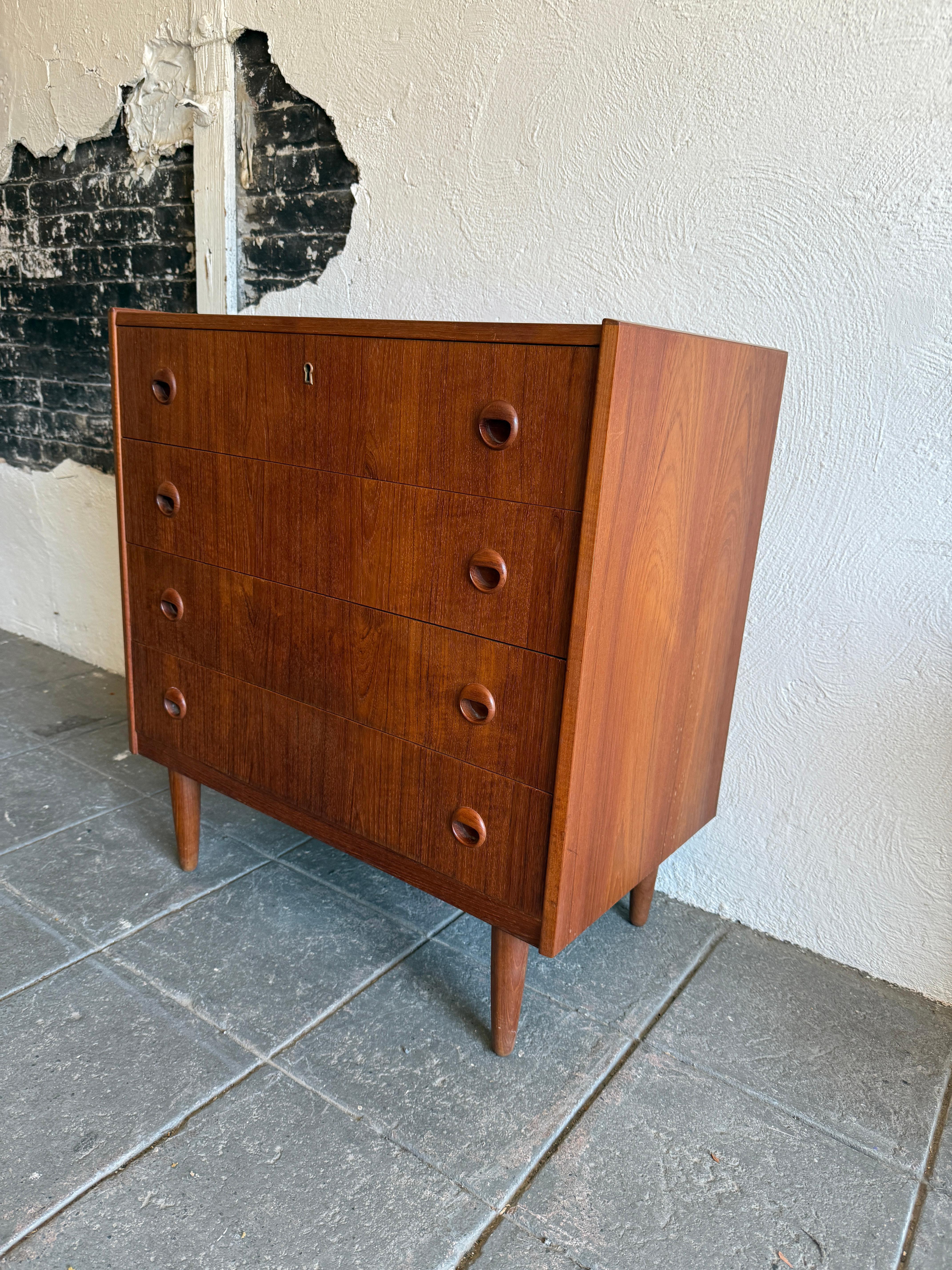 cómoda baja de 4 cajones de madera de teca de mediados del siglo xx sobre patas Moderno de mediados de siglo en venta