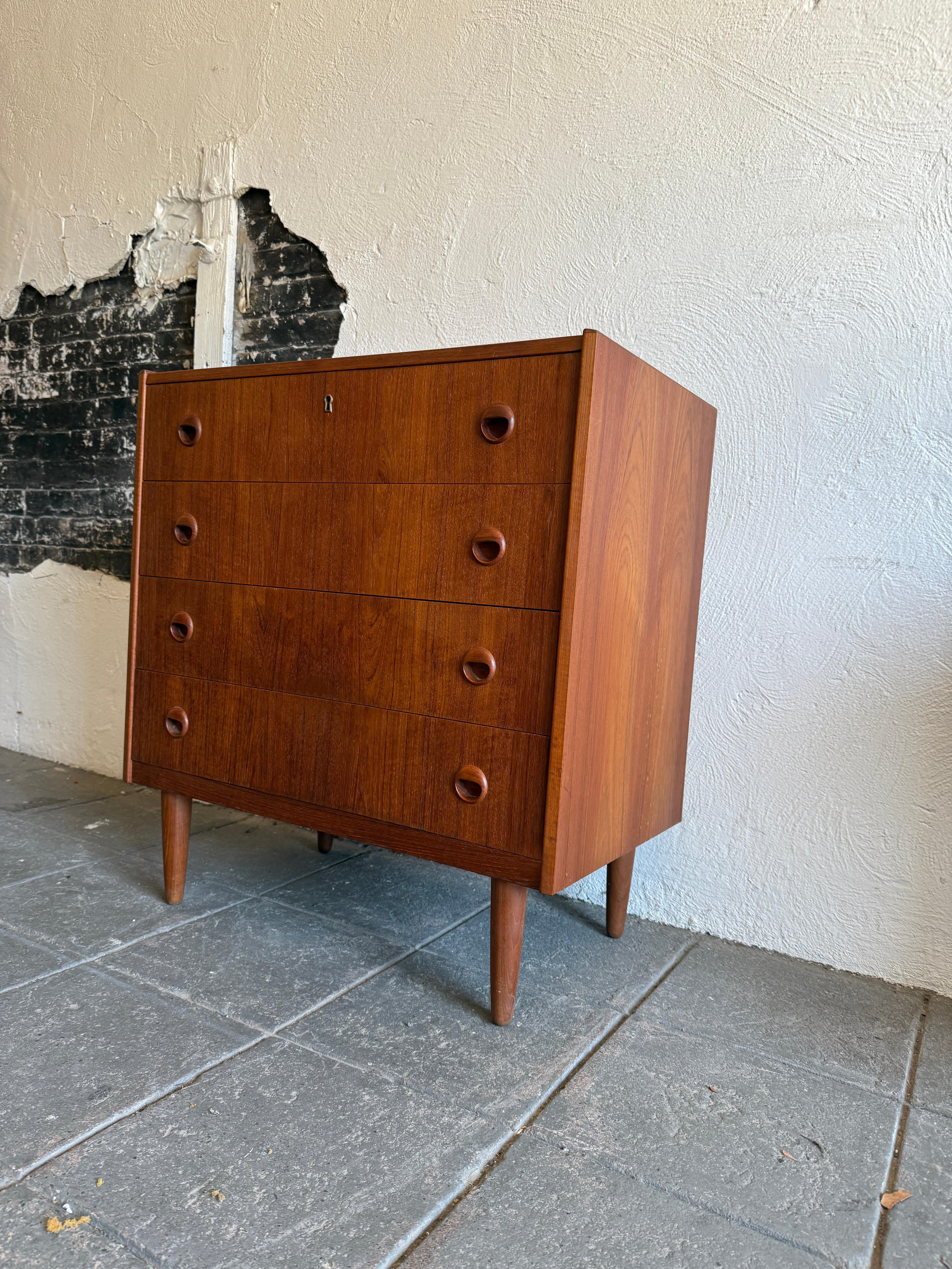 cómoda baja de 4 cajones de madera de teca de mediados del siglo xx sobre patas mediados del siglo XX en venta