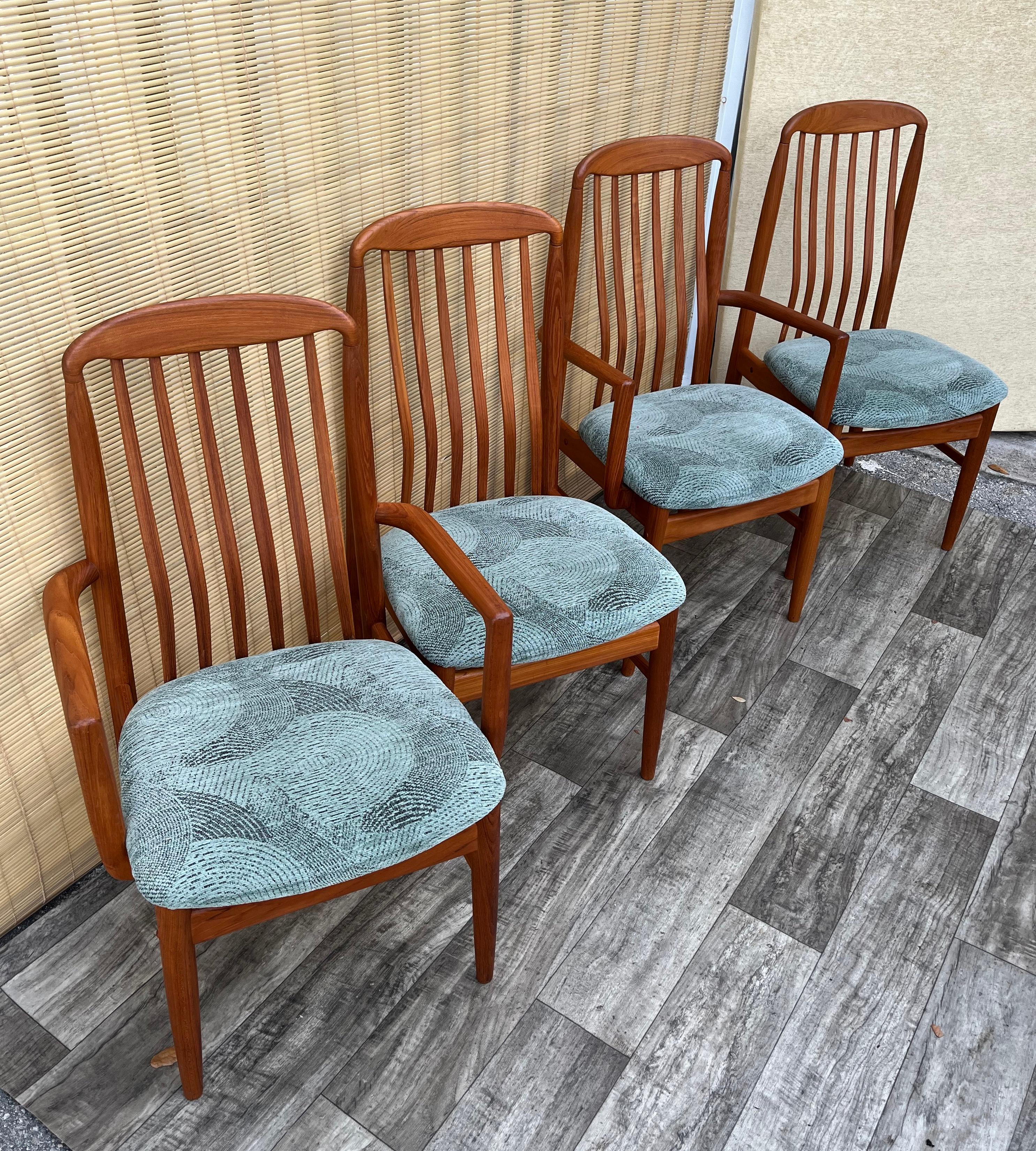 Vintage Mid-Century Danish Modern Style Dining Chairs by Benny Linden Design. Set of Four. Circa 1980s 
Two side and two captain chairs. 
Feature sculpted solid teak frames with round tapered legs,  slightly bend teak slats backrests, and the
