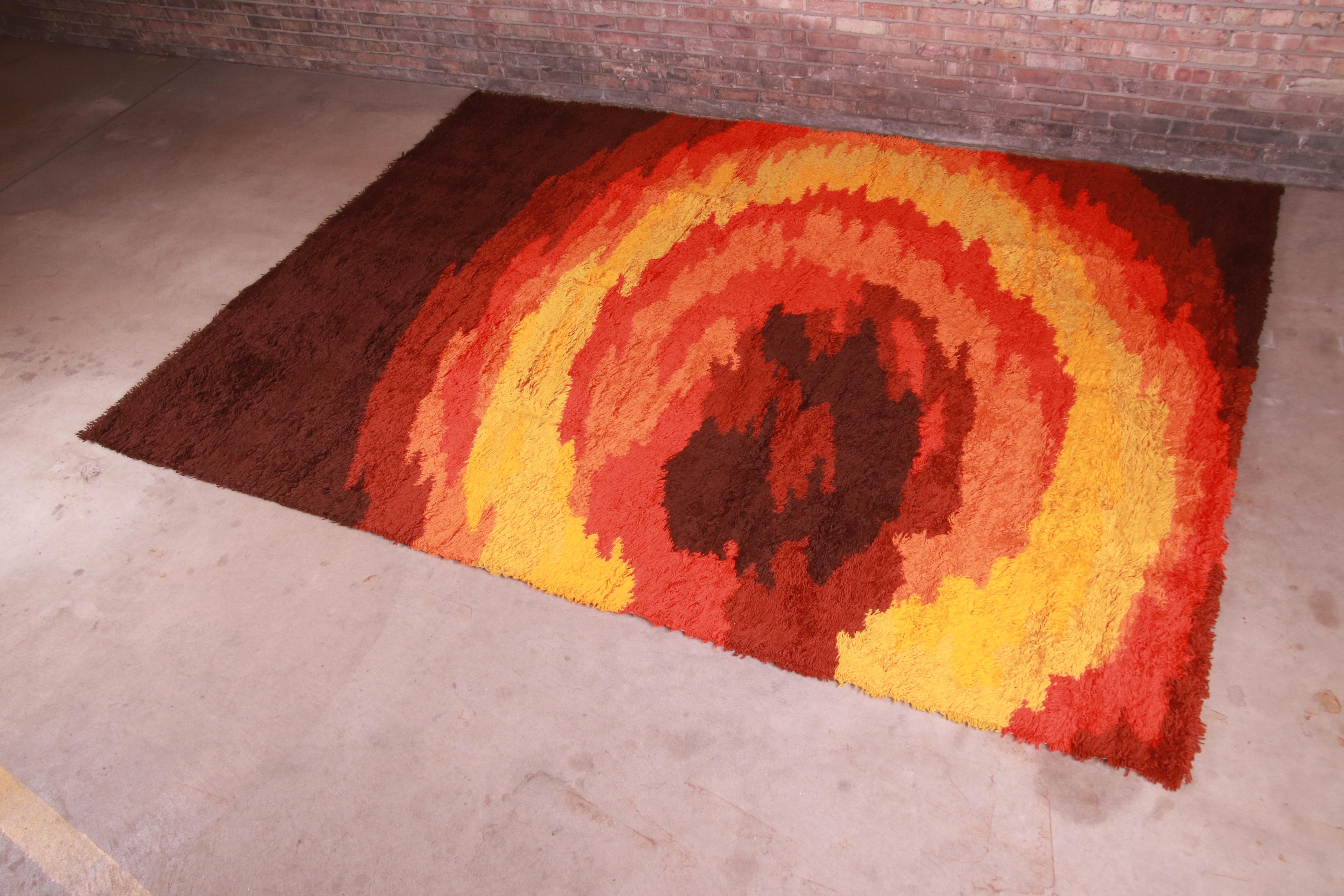 An outstanding mid-century Danish Modern style sunburst Rya shag wool rug

Produced by Thor for The Fritz and LaRue Co.

Austria, 1970s

Thick wool pile, with vibrant colors in red, orange, gold, and brown.

Measures: 8'2