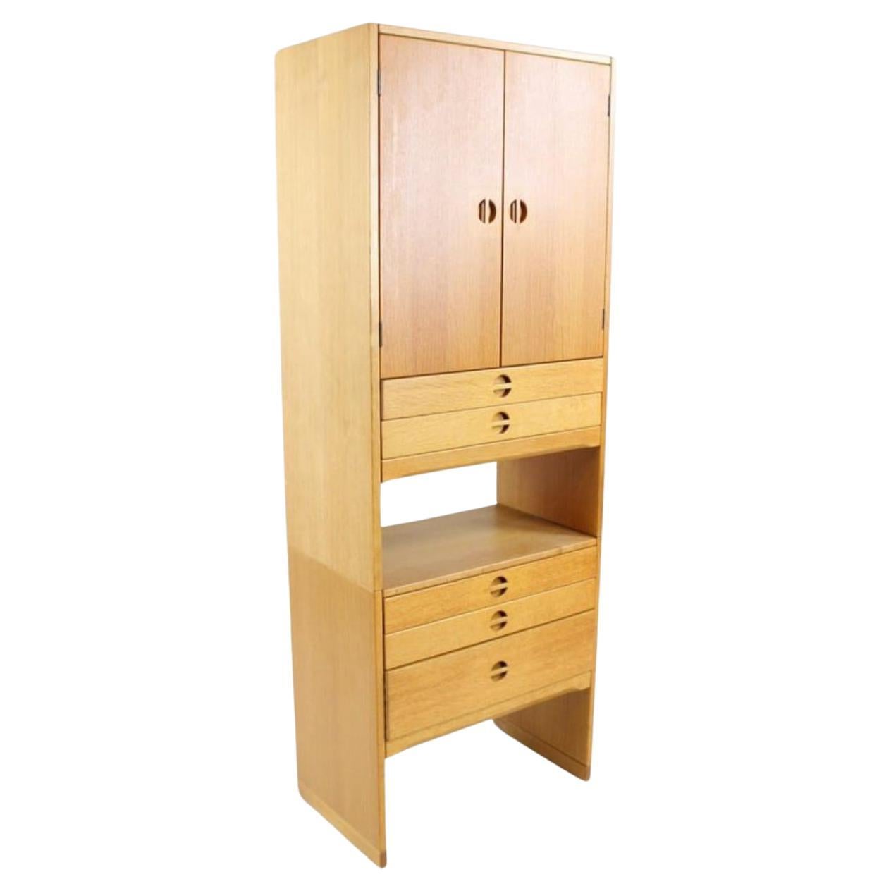 Mid Century Danish Modern Tall Narrow Cabinet by Aksel Kjersgaard Odder. This 2-piece standing storage unit contains 5 slide pull drawers below a 2-door cabinet that opens onto 3 shelves, a storage cubby between the two cabinet pieces. Drawer pulls
