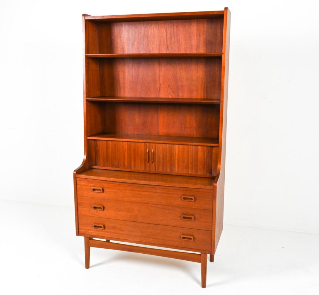 Mid Century Danish Modern Tall Teak Bücherregal unteren Kommode Schreibtisch Sekretär von Designer Johannes Sorth. Dieses hohe Bücherregal / Sekretär hat 3 obere Bücherregale mit mittleren Tambour-Türen, die 3 kleine Schubladen mit einem Organizer