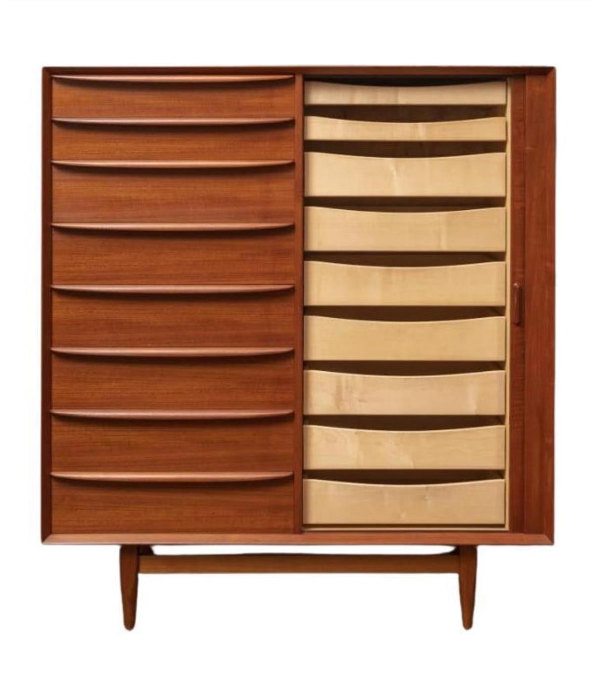 Mid century Danish Modern tall teak dresser has 8-drawers on left. Clean inside and out - labeled Falster - Made in Denmark. Good vintage condition. Has right cabinet door with 9 drawers behind the Tambour door. Very clean all around inside and out.