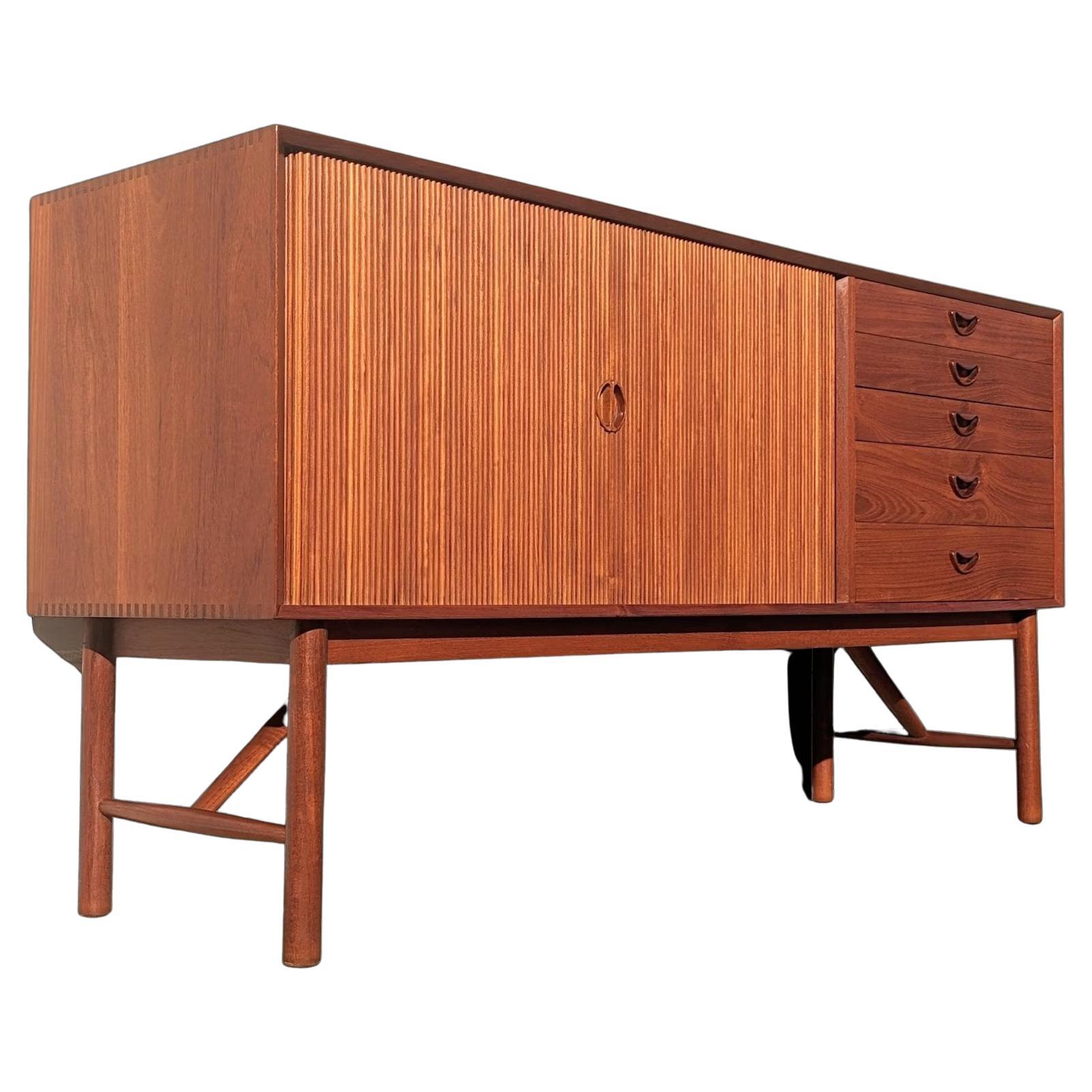 Mid Century Danish Modern Tambour Door Sideboard by Hvidt & Molgaard

Above average vintage condition and structurally sound. Has some expected very slight finish wear and scratching. Very good condition. Has one small clear drop of what appears to