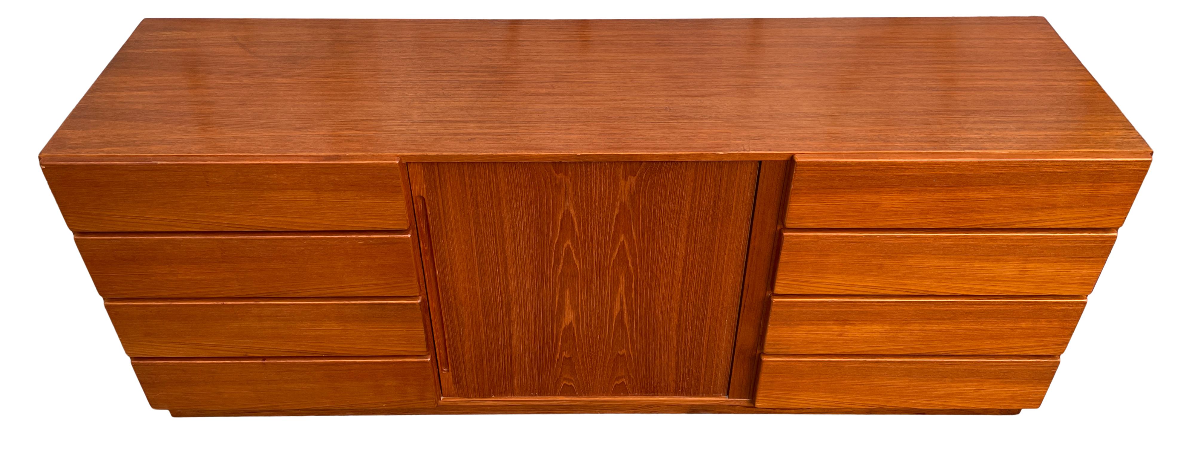 Mid-century Danish modern Tambour door credenza dresser with 8 drawers front drawers. Light teak credenza or dresser with front sliding Tambour doors behind the doors are 3 teak drawers with 2 adjustable shelves. All drawers are clean and slide