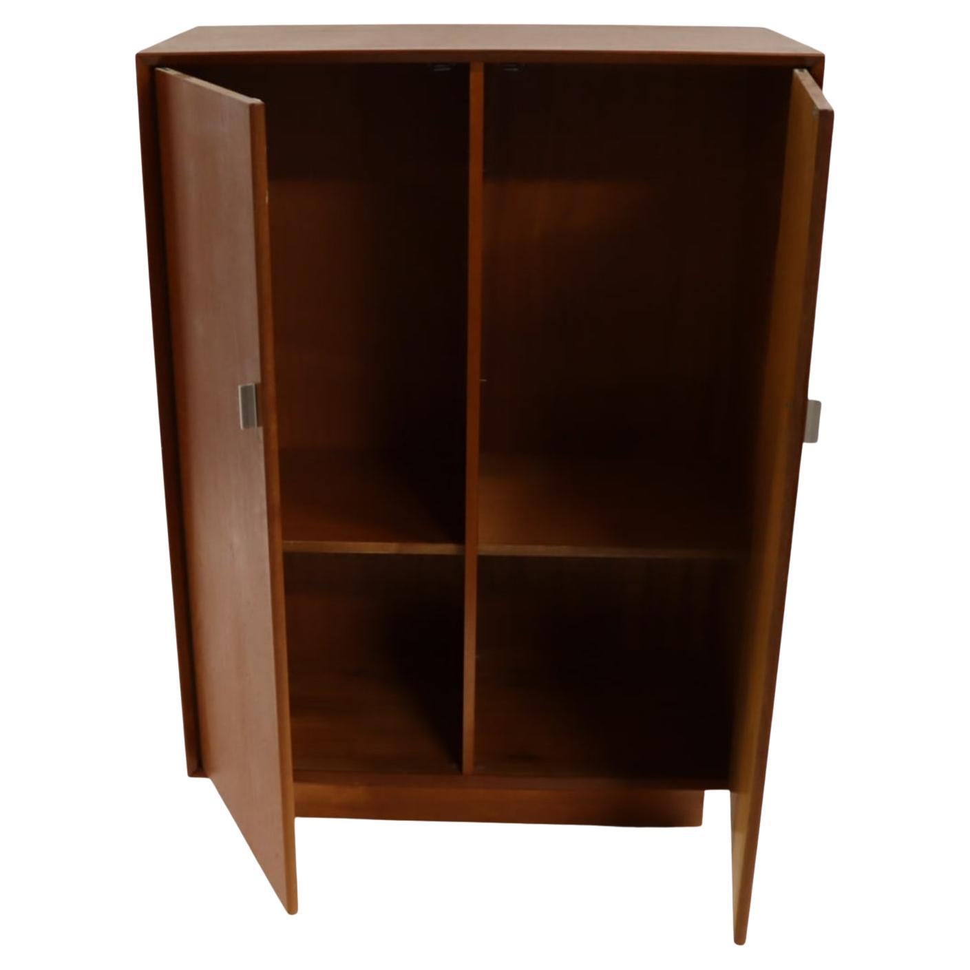 Mid century danish modern teak 2 door wardrobe cabinet. Behind the doors are open shelves. (8) adjustable shelves total with pins. (4) on the left and (4) on the right side. Great for storage. Labeled Made in Denmark. Located in Brooklyn
