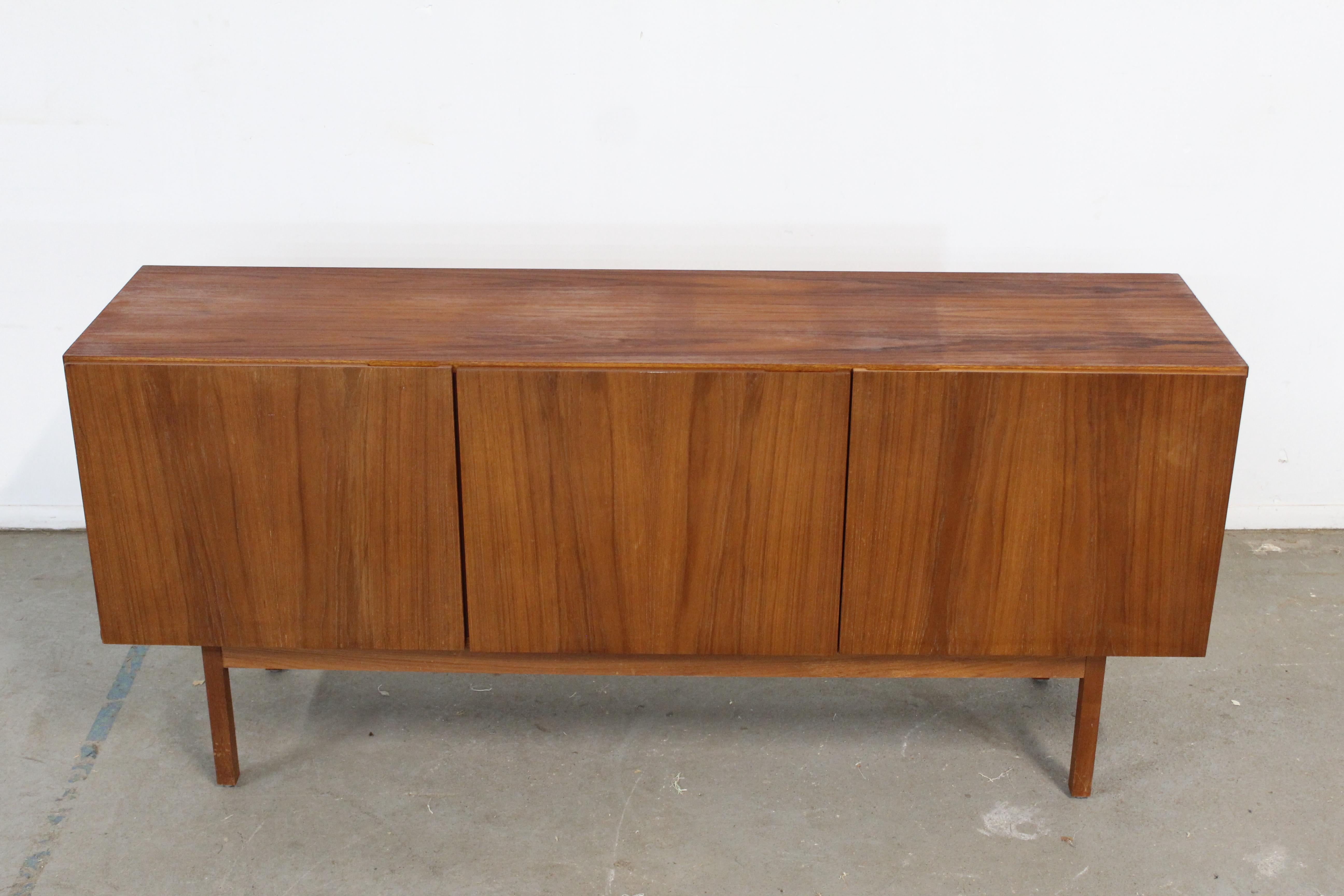 Mid-Century Danish Modern teak Credenza

Offered is a teak credenza. This piece makes a statement and will make a nice feature piece in any room. Features pencil legs, three doors with shelving and 2 drawer. It is in good condition, showing some