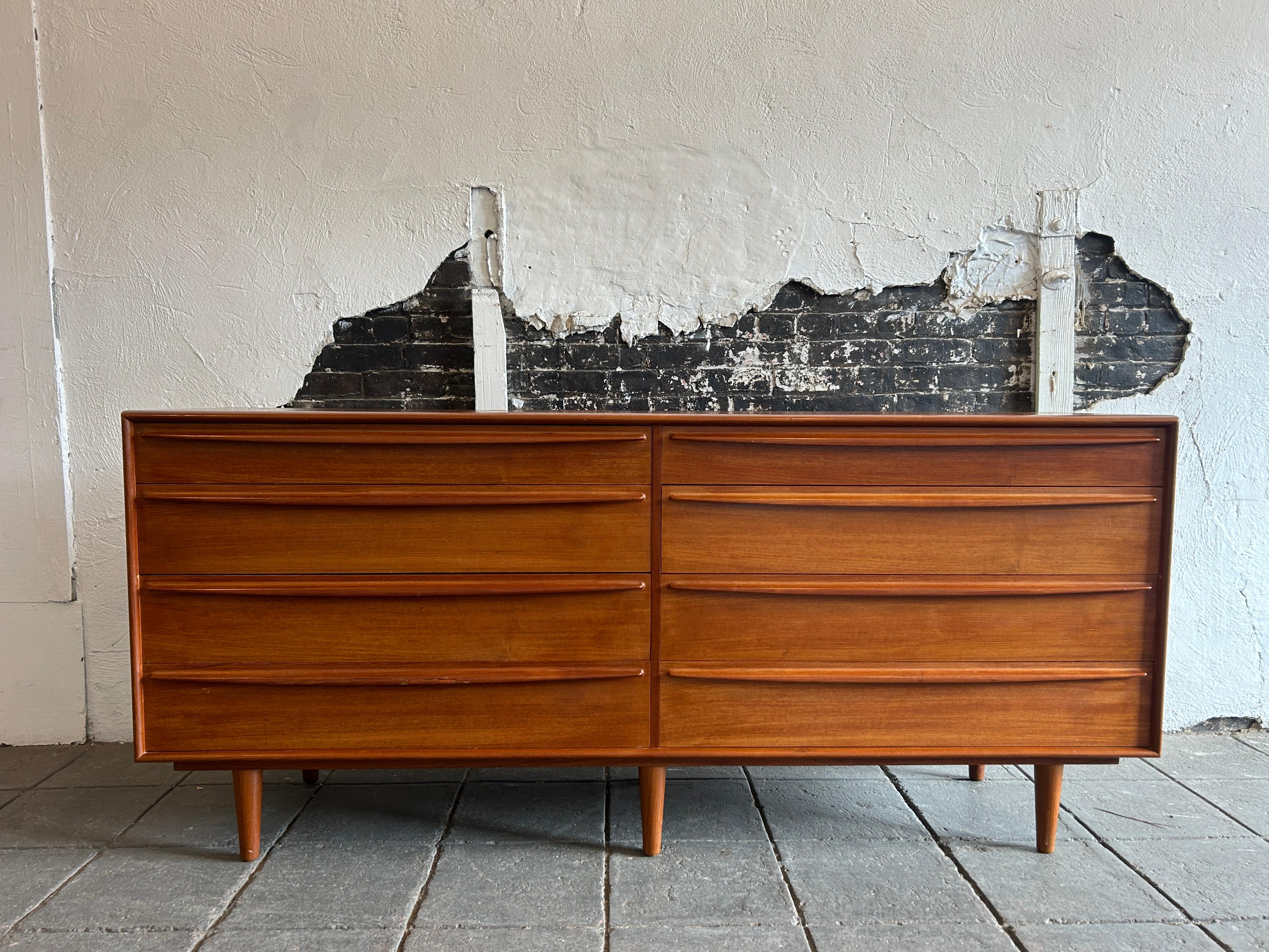 Superb Mid century danish modern teak 8 drawer dresser with sculpted handles. Beautiful Danish modern 8 drawer dresser with 8 drawer with curved rounded handles. Sits on 6 tapered wood legs. High quality Danish woodwork. All drawers slide smooth