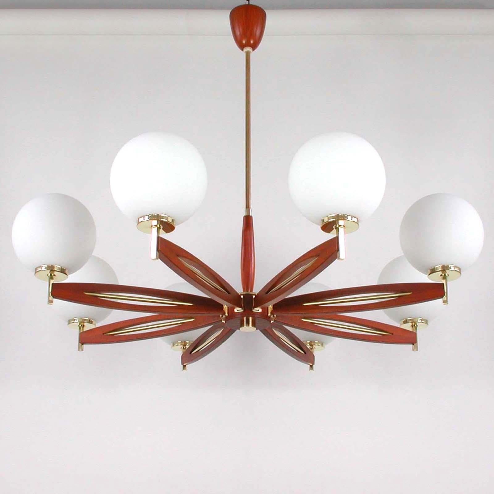 This sputnik eight-light chandelier was manufactured in Denmark in the late 1950s-early 1960s. It is made of brass and teak and has got eight satin opal glass lampshades.

Condition is very good and the lamp is in full working order, cleaned and