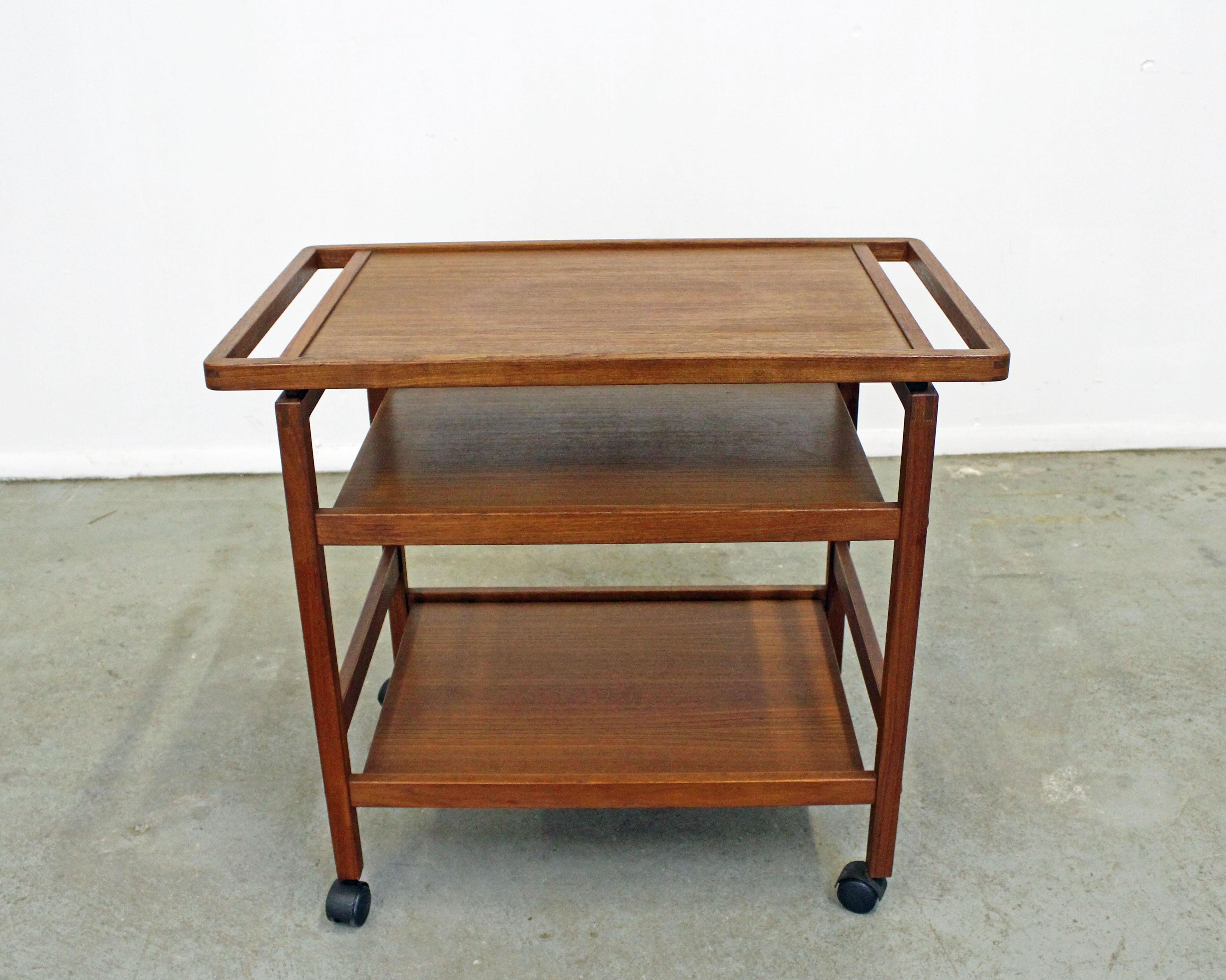 What a find. Offered is a Danish Modern teak serving cart on black castor wheels with a removable top. Great for storage, serving drinks, or food. It is in excellent condition, showing minor age wear (minor surface wear/scratches, age wear--see