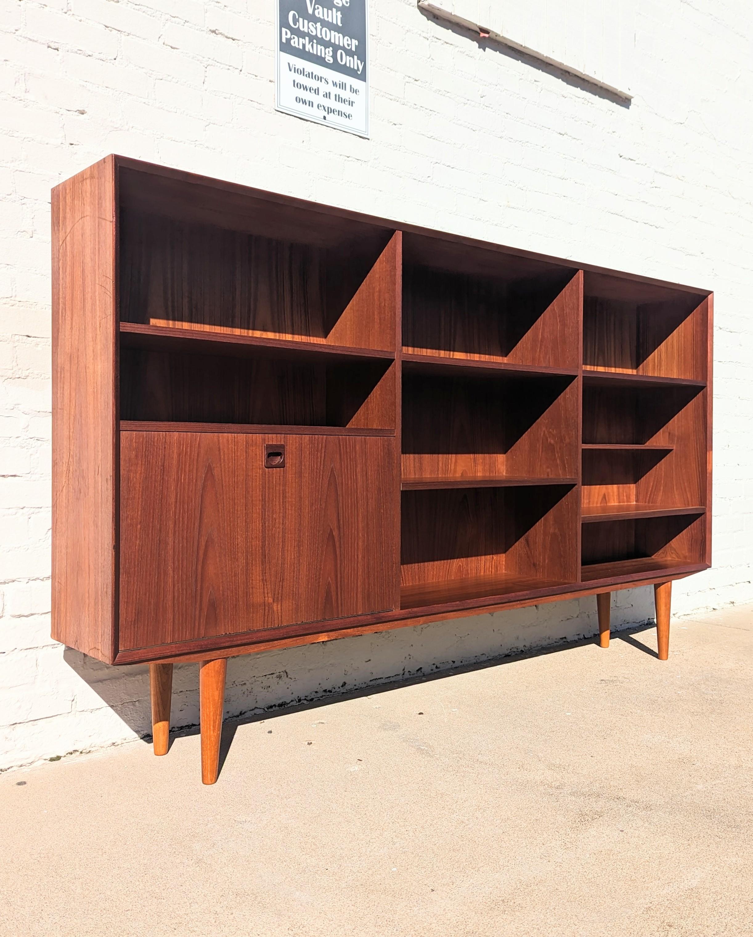Large, impressive teak bookcase from Denmark.  Provides lots of storage in addition to being very attractive. Above average condition and structurally sound. It does have some discolorations on a couple of shelves and some edge dings in a couple of