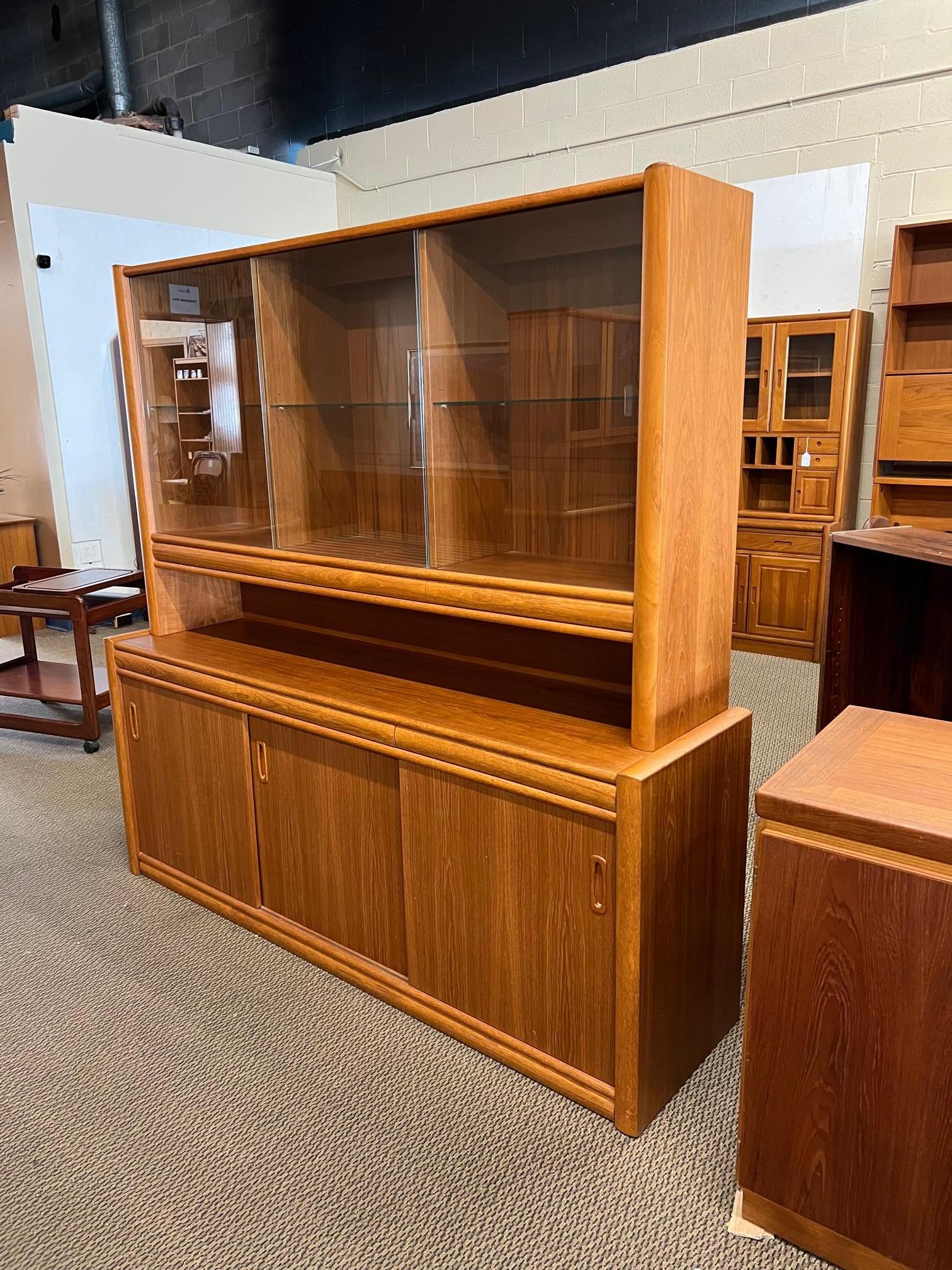 Teak buffet with display hutch. Lots of storage. It has lights that work. Adjustable shelves. Fantastic condition. Middle drawer does not open as far as the the two outer drawers.

Dimensions:

Bottom piece 71