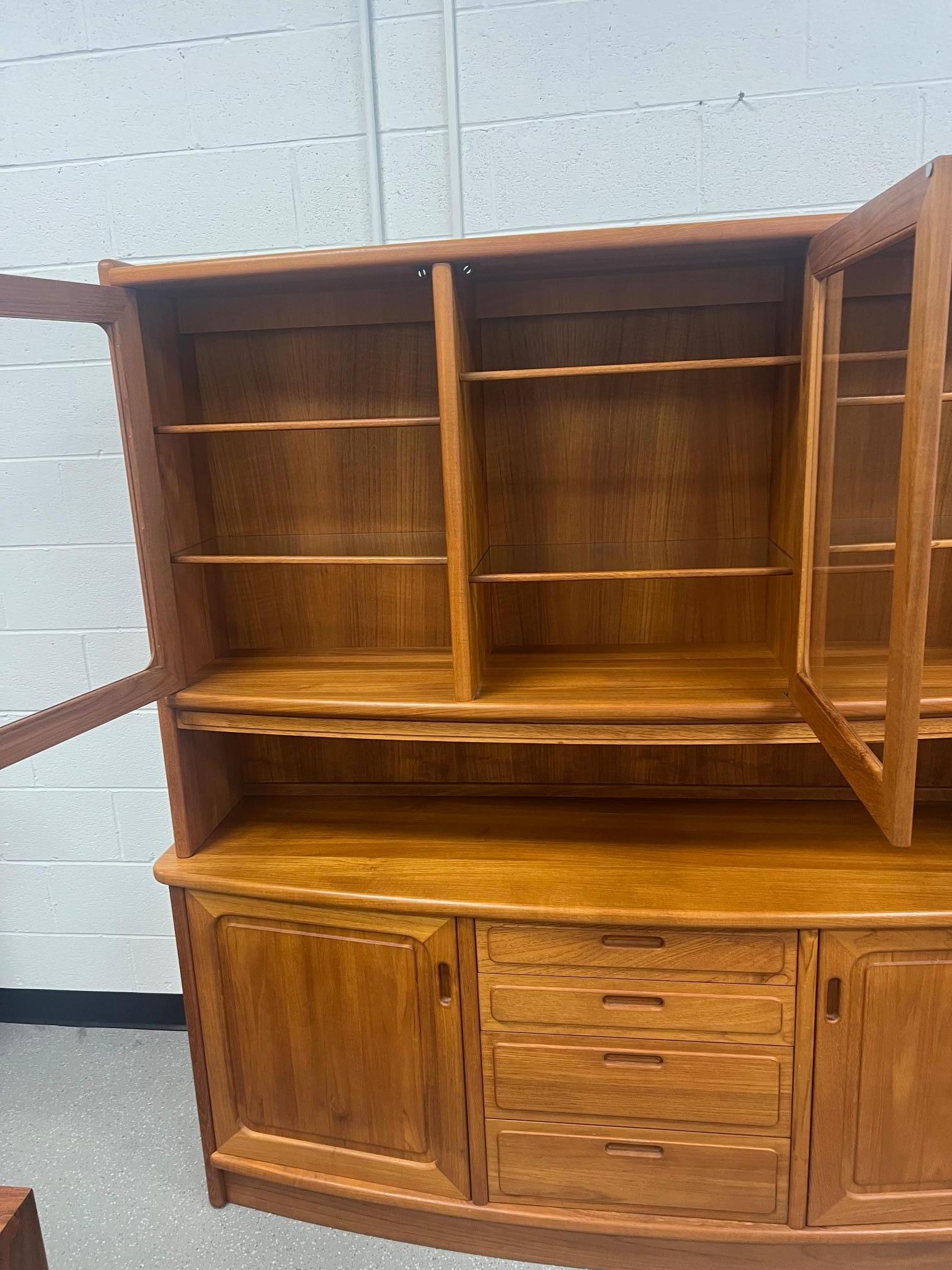 Gorgeous Danish Modern teak buffet with hutch. Bow front design. No manufacturer label found. A brochure was inside indicating it was purchased at the house of Denmark.

Featuring adjustable glass shelves at the top. Adjustable wood shelves at the