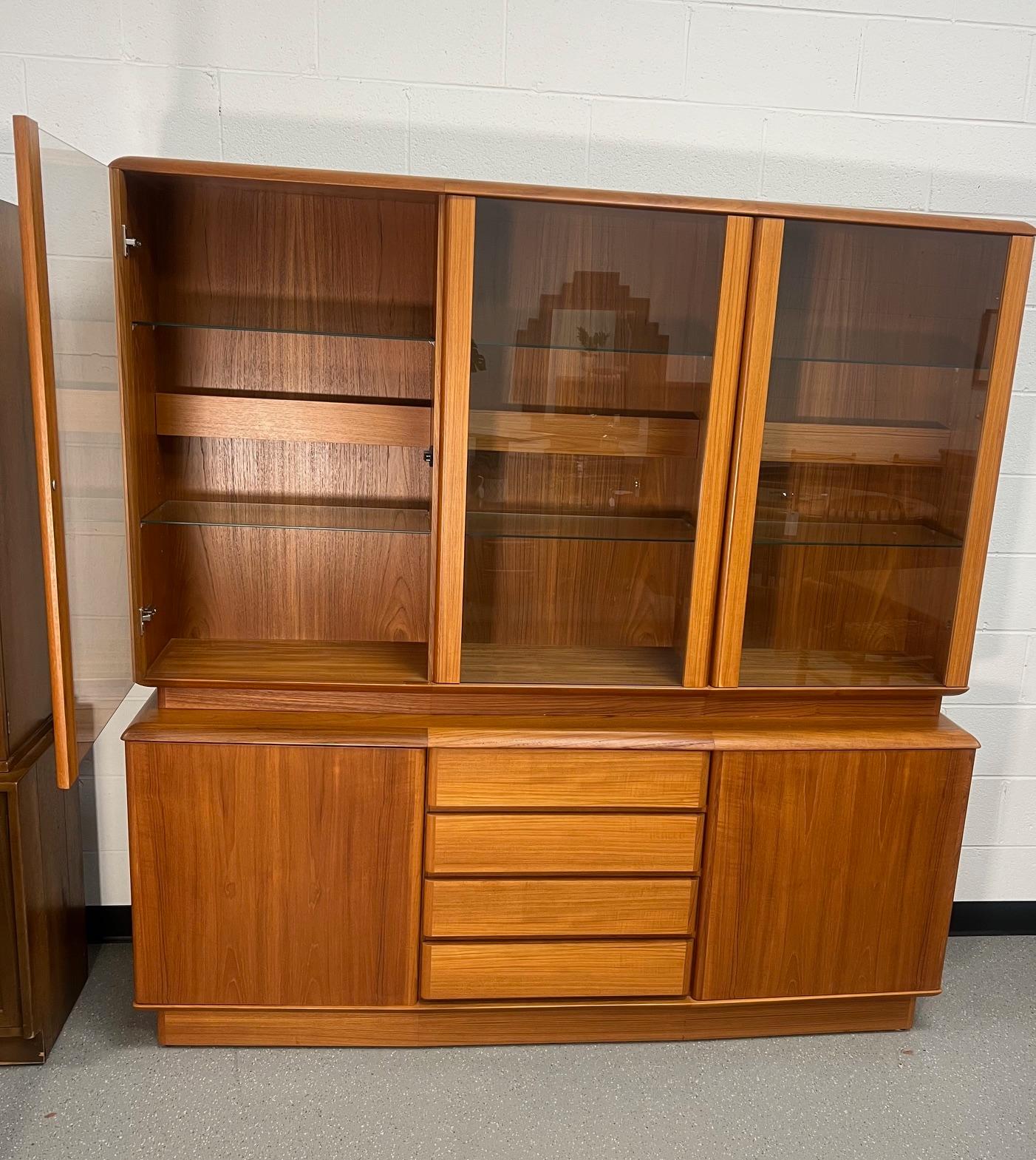 Gorgeous Danish Modern teak buffet with hutch. Bow front design.

Featuring 6 adjustable glass shelves at the top. Adjustable wood shelves at the bottom and four clean drawers. Middle glass door sticks a little when opening. 

Fantastic condition.