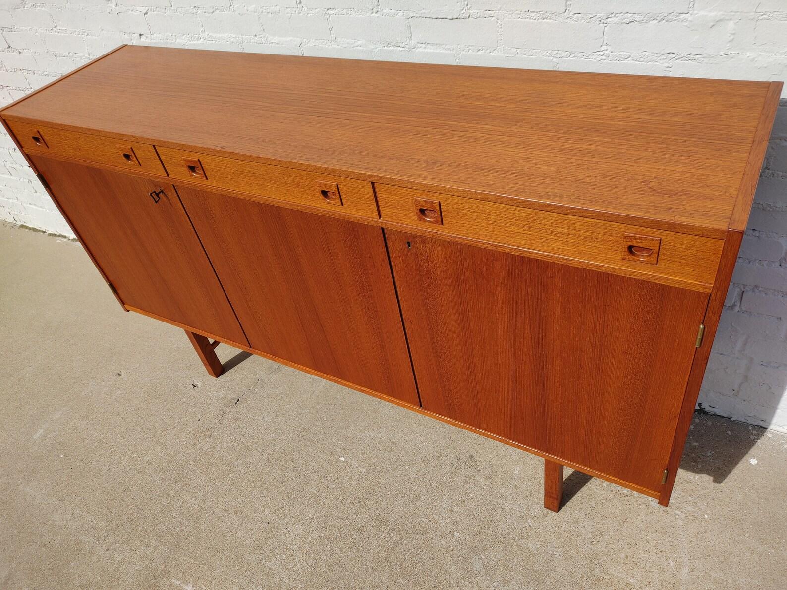 Mid Century Danish Modern Teak Cabinet

Above average vintage condition and structurally sound. Has some expected slight finish wear and scratching. Top has been refinished and does not have original factory finish. Outdoor listing pictures might