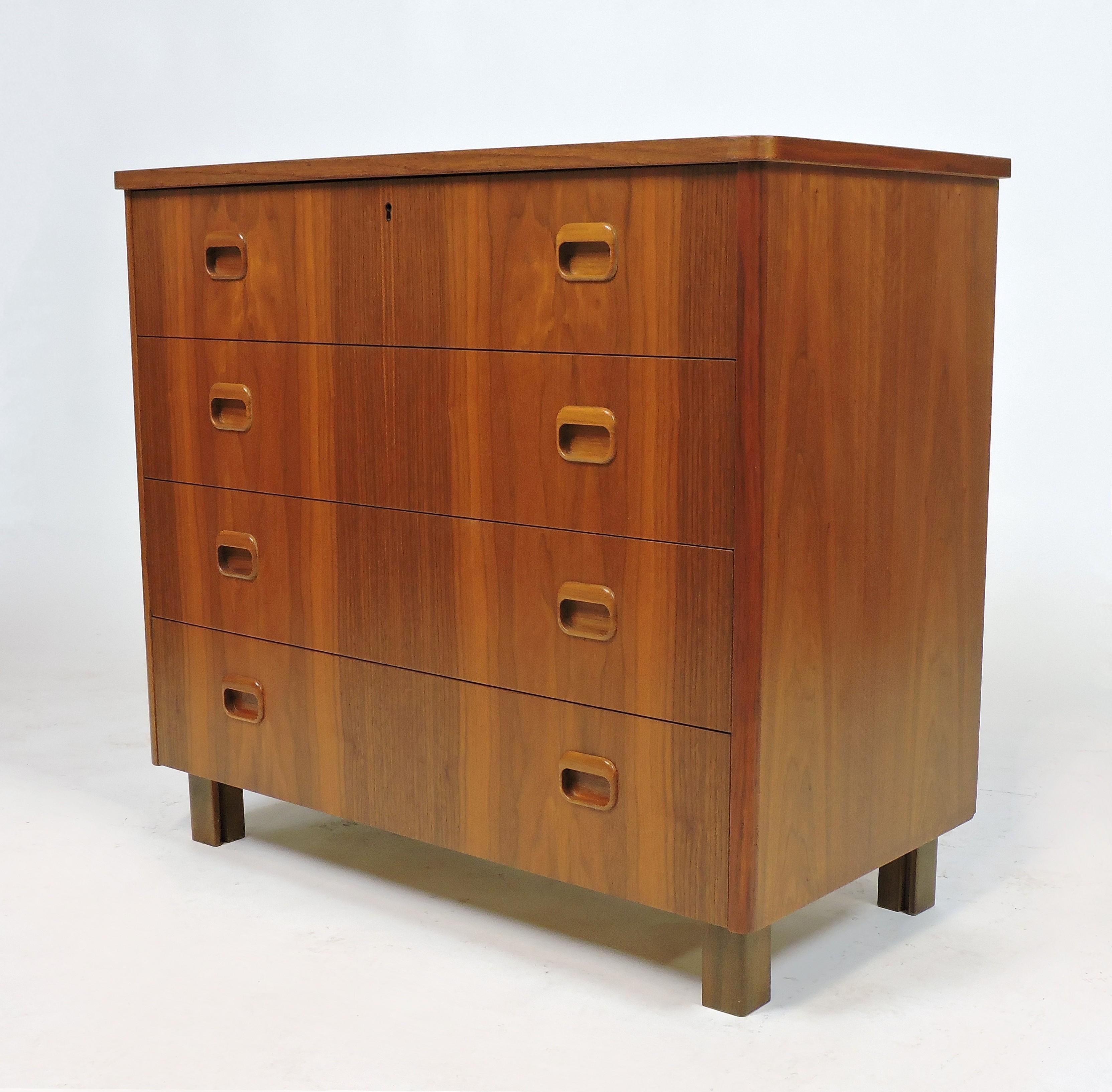 Beautiful teak dresser made in Sweden by Sveriges Mobel IndustI Forbund (Swedish Furniture Makers Association). This cabinet has four drawers with sculpted recessed pulls and a striking wood grain.

   
