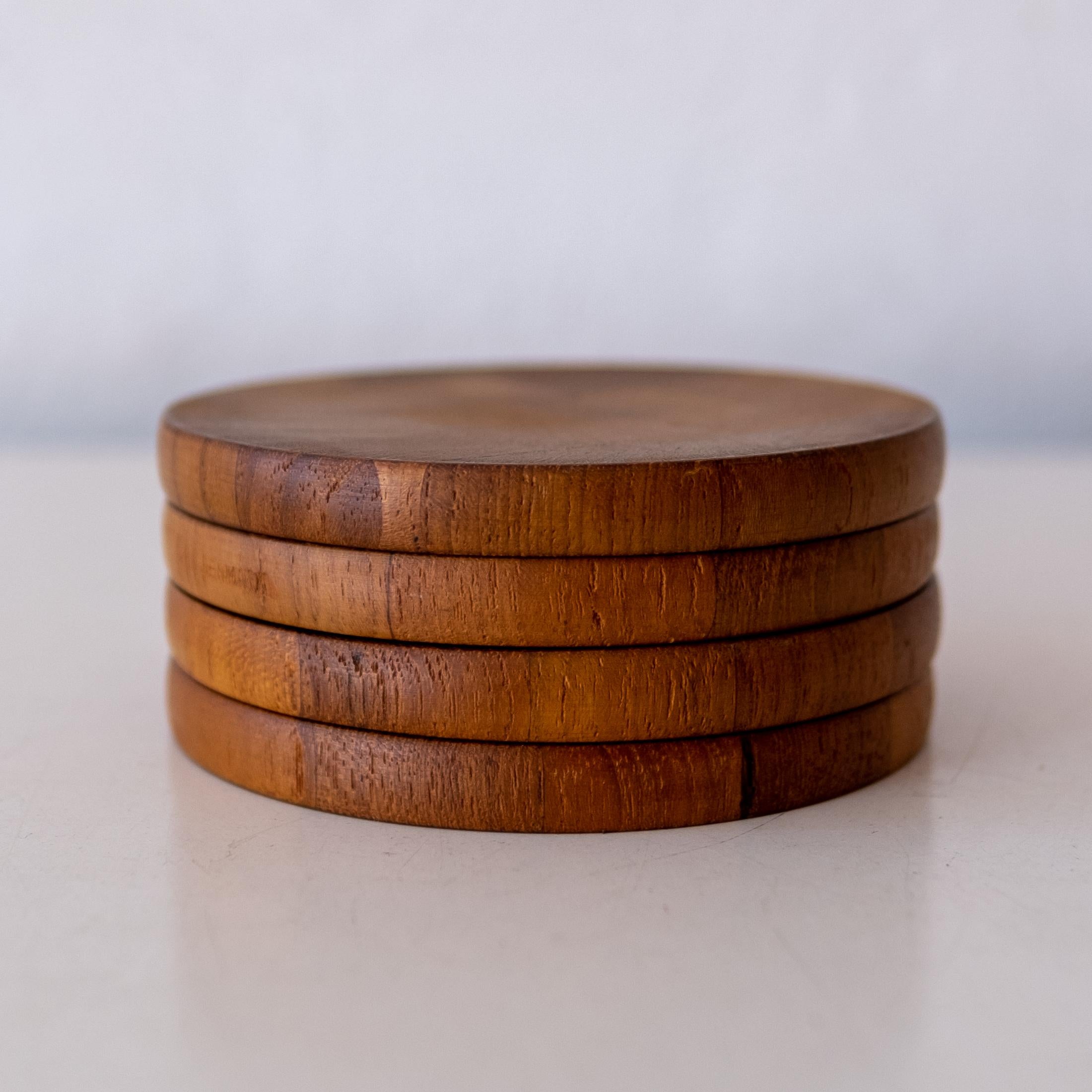 Mid-Century Danish Modern teak coaster set by Jens H. Quistgaard for Dansk. Includes four coasters in the original box. Solid teak. Denmark, 1950s.