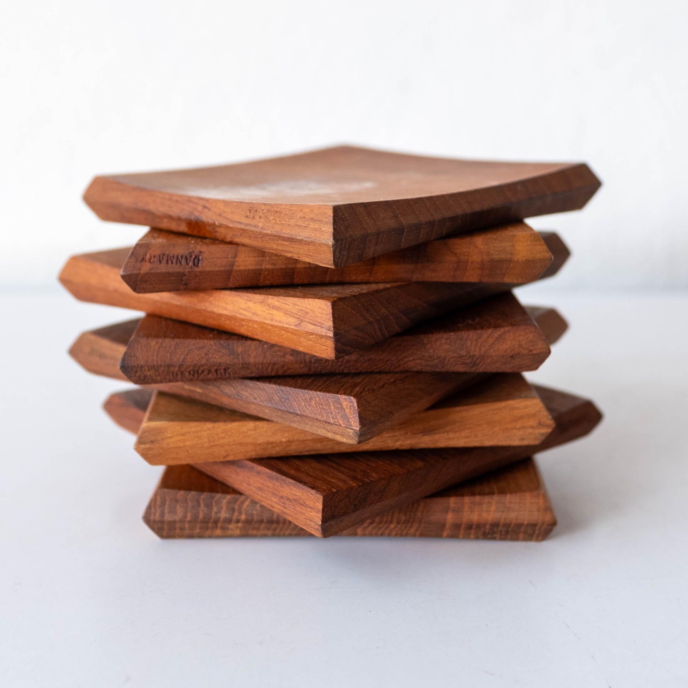 Mid-Century Danish Modern teak coaster set by Jens H. Quistgaard for Dansk. Concave design with beveled edges make for a lot of design packed into a coaster. Includes 8 coasters in the original boxes. One box is missing the lid. Solid teak. Each