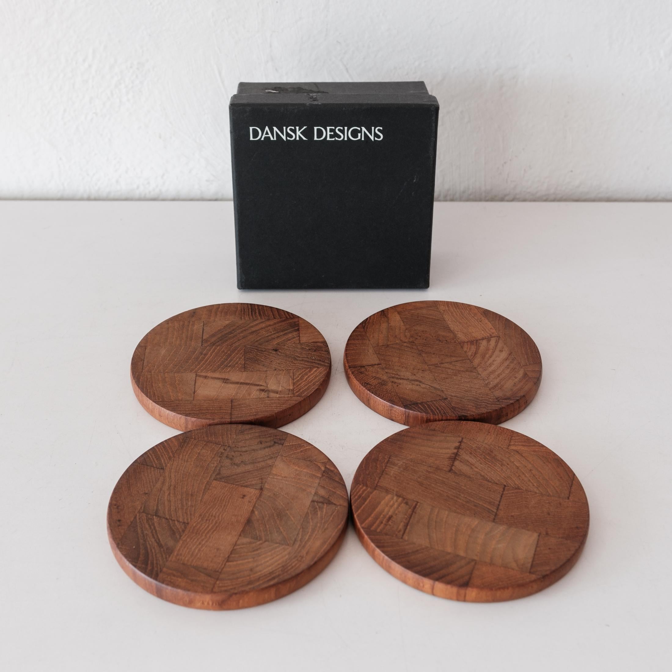 Mid-Century Danish Modern teak coaster set by Jens H. Quistgaard for Dansk. Includes four coasters in the original box. Each coaster is stamped, JHQ Denmark. Solid teak. Denmark, 1950s.