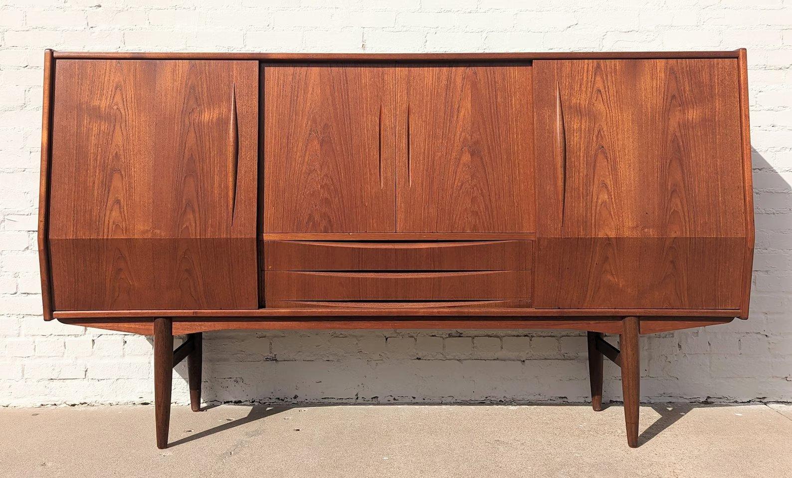 Mid Century Danish Modern Teak Cocktail Cabinet

Above average vintage condition and structurally sound. Has some expected slight finish wear and scratching. Has a couple small dings and discolorations on top. Outdoor listing pictures might appear
