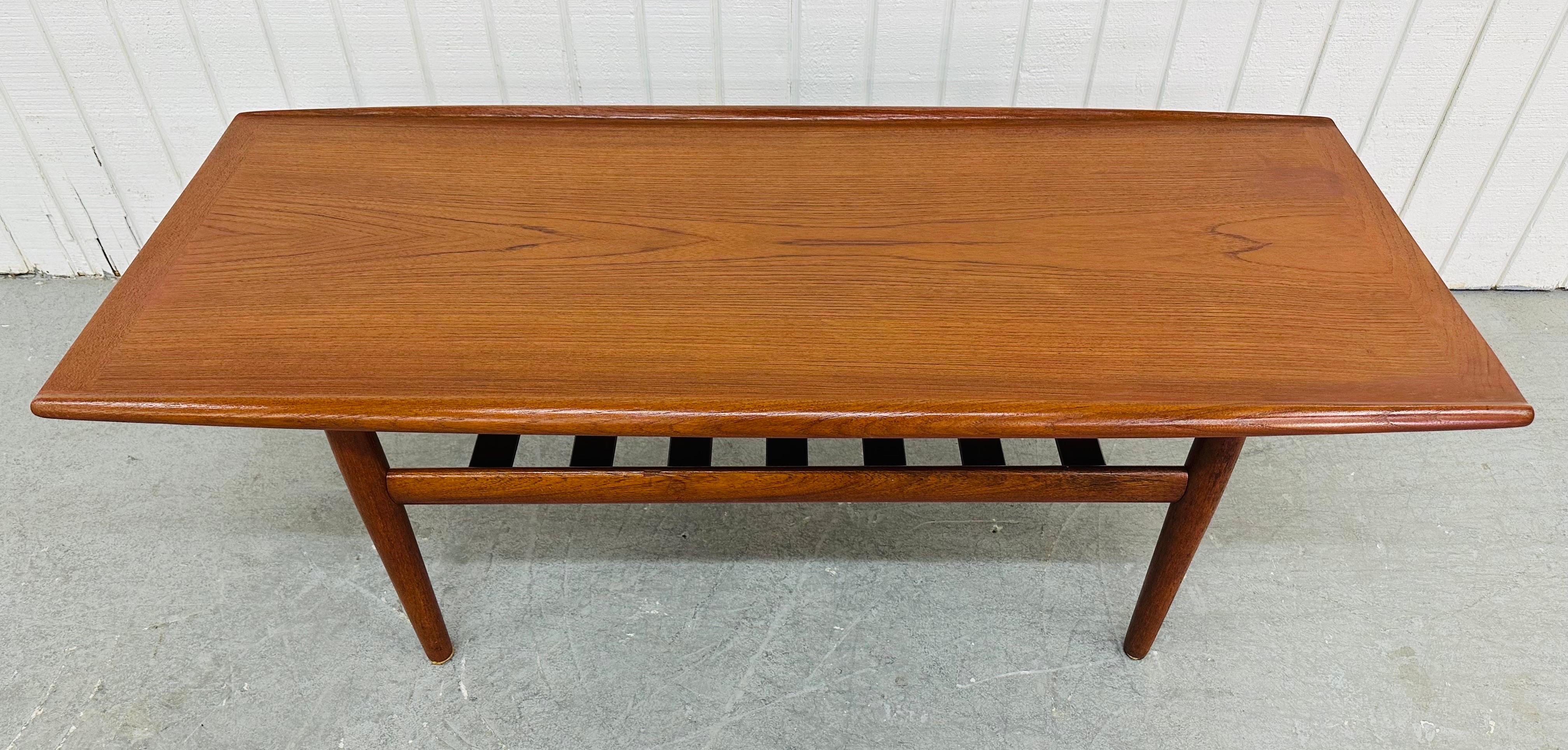 This listing is for a Mid-Century Danish Modern Teak Coffee Table. Featuring a rectangular top with curved edges, modern legs, a lower tier magazine rack, and a beautiful teak finish. This is an exceptional combination of quality and design!