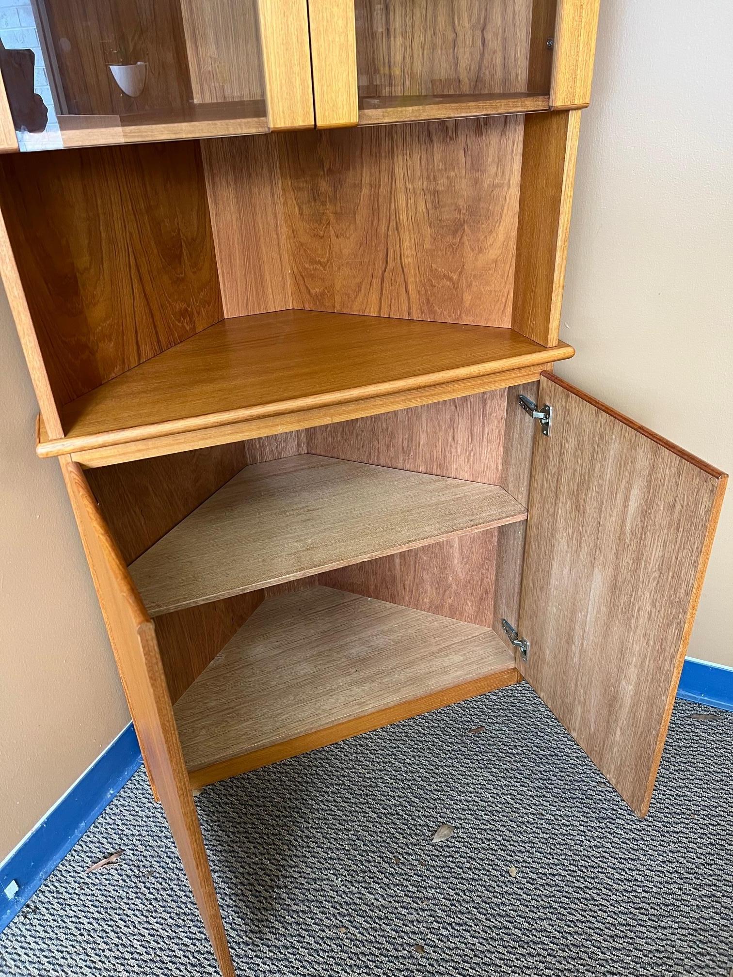 Outstanding Danish teak corner cabinet. Adjustable glass shelves at the top. Adjustable wood shelf at the bottom. Top has a light. Power cord is mounted on the top.
Excellent condition.
Dimensions: width 34