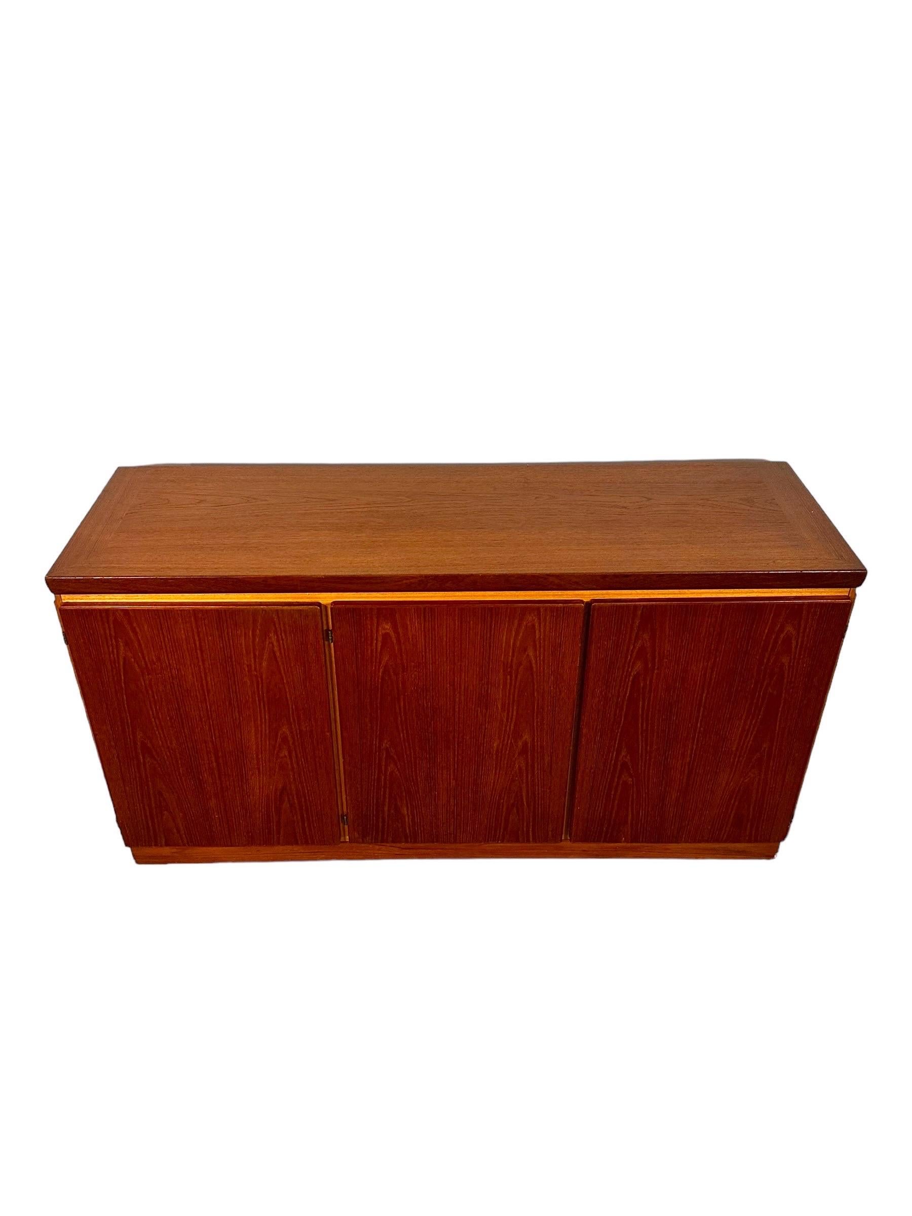Introducing this sleek Mid Century Danish Modern Teak Credenza, a timeless piece embodying the minimalist aesthetics of the era. At 60.25 inches in width, 19 inches in depth, and 32 inches in height, it offers ample storage space without