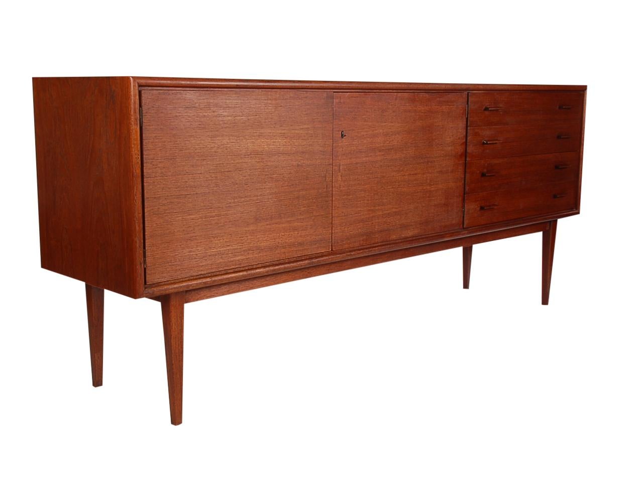 A beautifully designed and well proportioned European cabinet from the 1960s. This credenza features teak finishes with plenty of interior storage. Recently refinished and in beautiful condition.