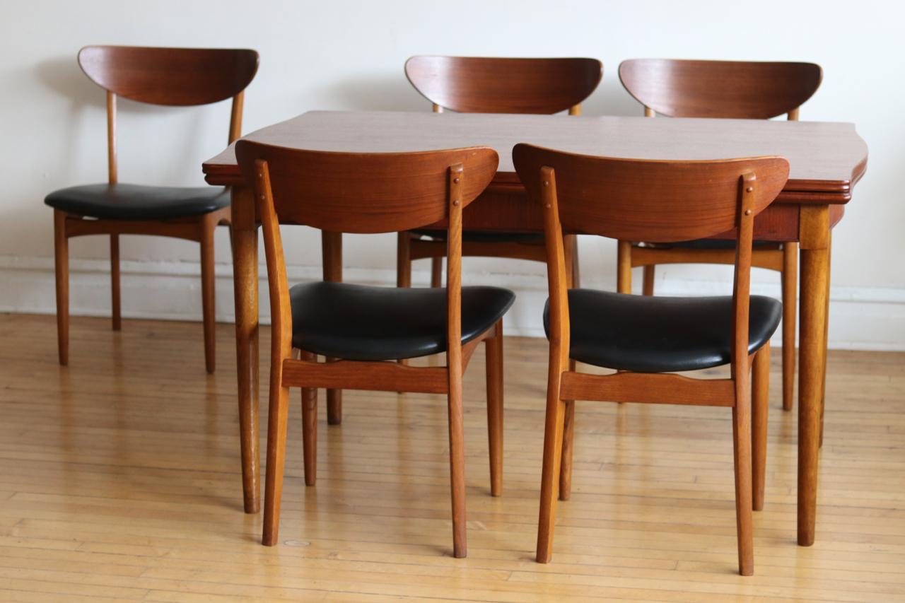 Mid-Century Modern Danish teak wood expanding dining table and 5 chairs.
Just imported from Denmark.
Refinished two-toned table features curved self-storing leaves on each end.
Includes five Scandinavian chairs with new black vinyl upholstery and