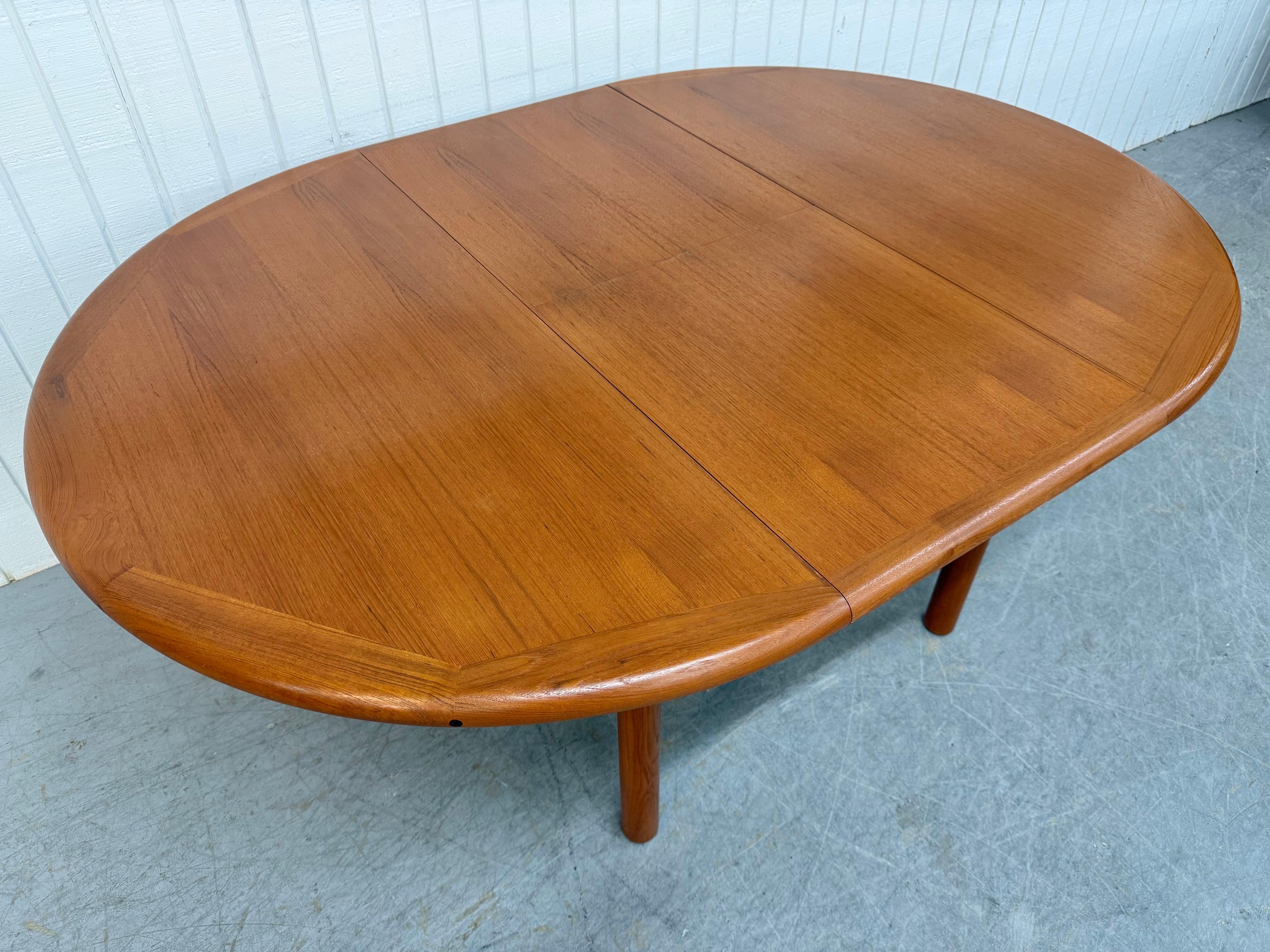 Cette annonce concerne une table de salle à manger en teck moderne danoise du milieu du siècle. Elle est dotée d'un plateau rond de 48 pouces, de feuilles escamotables cachées qui agrandissent la table à un plateau ovale de 68 pouces, de quatre