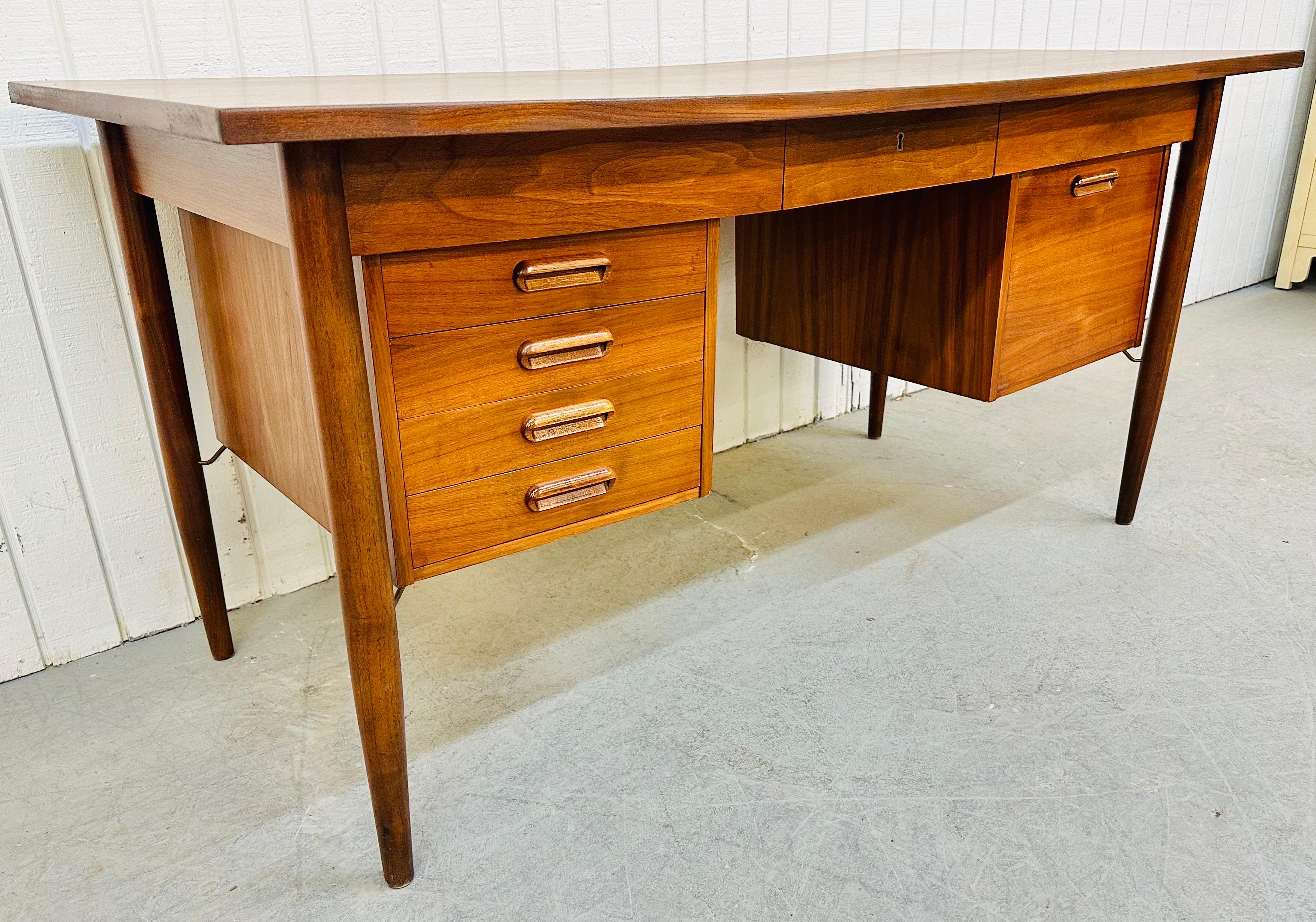 This listing is for a midcentury Danish Modern Teak Executive Desk. Featuring a large rectangular teak top, four legs with floating drawers that give this piece a free formed design, one large drawer for storage, four small drawers for storage, a
