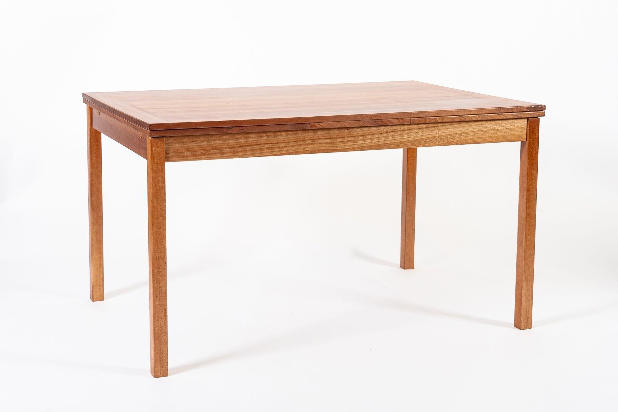 Cette table de salle à manger extensible en teck de style moderne danois du milieu du siècle a été fabriquée au Danemark vers 1960. Cette magnifique table aux lignes épurées, minimalistes et géométriques est robuste et bien construite en teck. Les