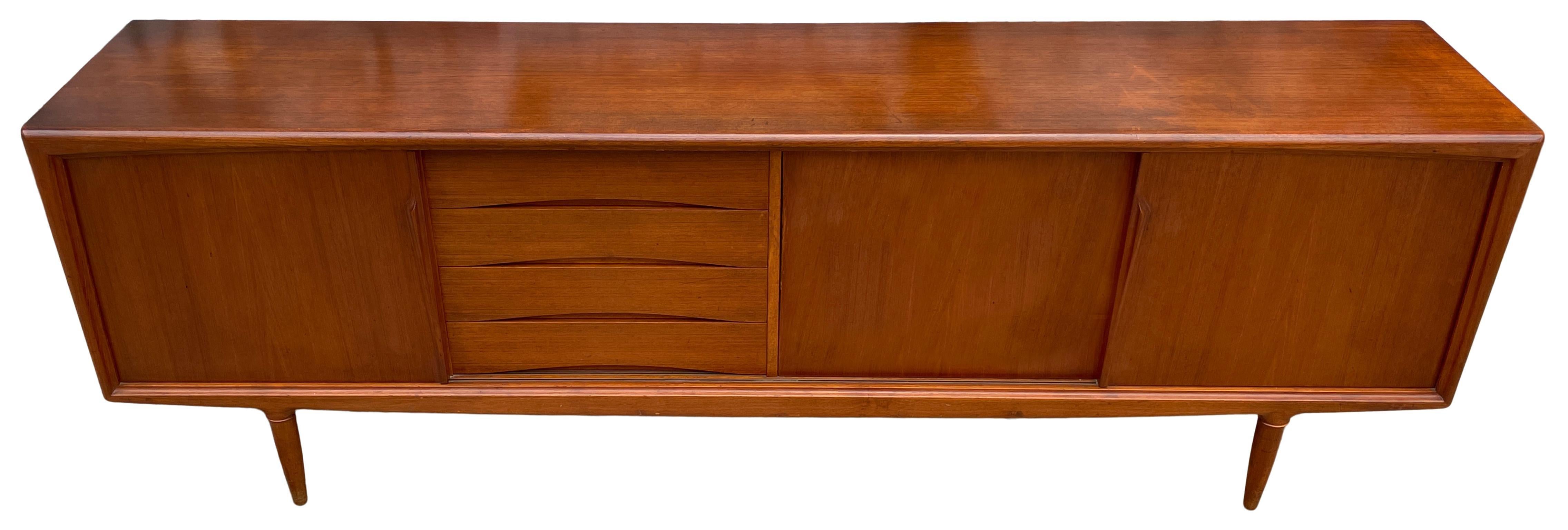 Credenza moderna danese di metà secolo in teak Gunni Omann. Ha 4 cassetti con feltro all'interno e 3 ante scorrevoli. Questa credenza lunga 94