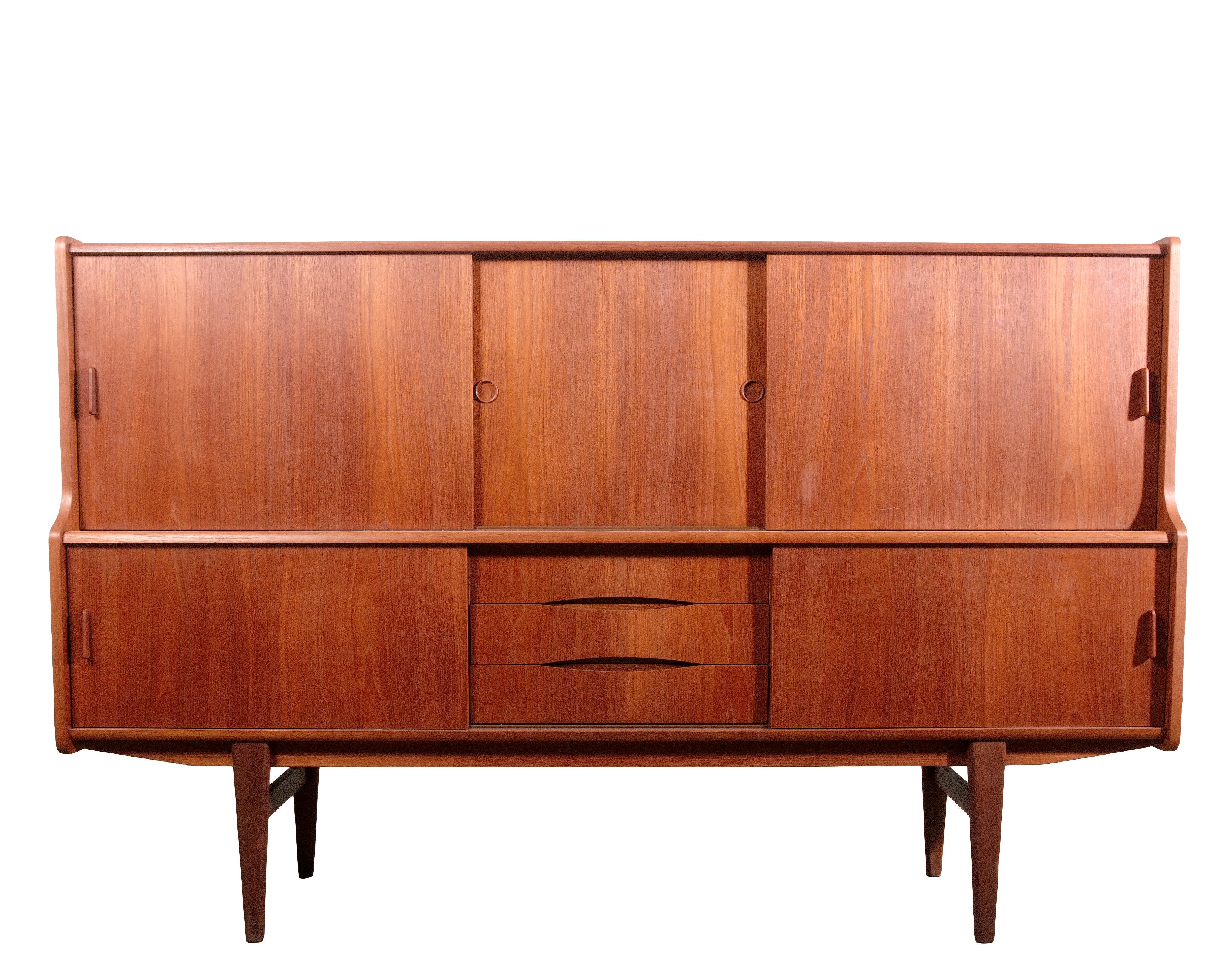 Questa credenza in teak danese moderna del Mid-Century è un pezzo raffinato, che unisce senza sforzo funzionalità e design senza tempo, con la versatilità di essere una credenza o un bancone. La nicchia centrale, progettata con cura, offre uno