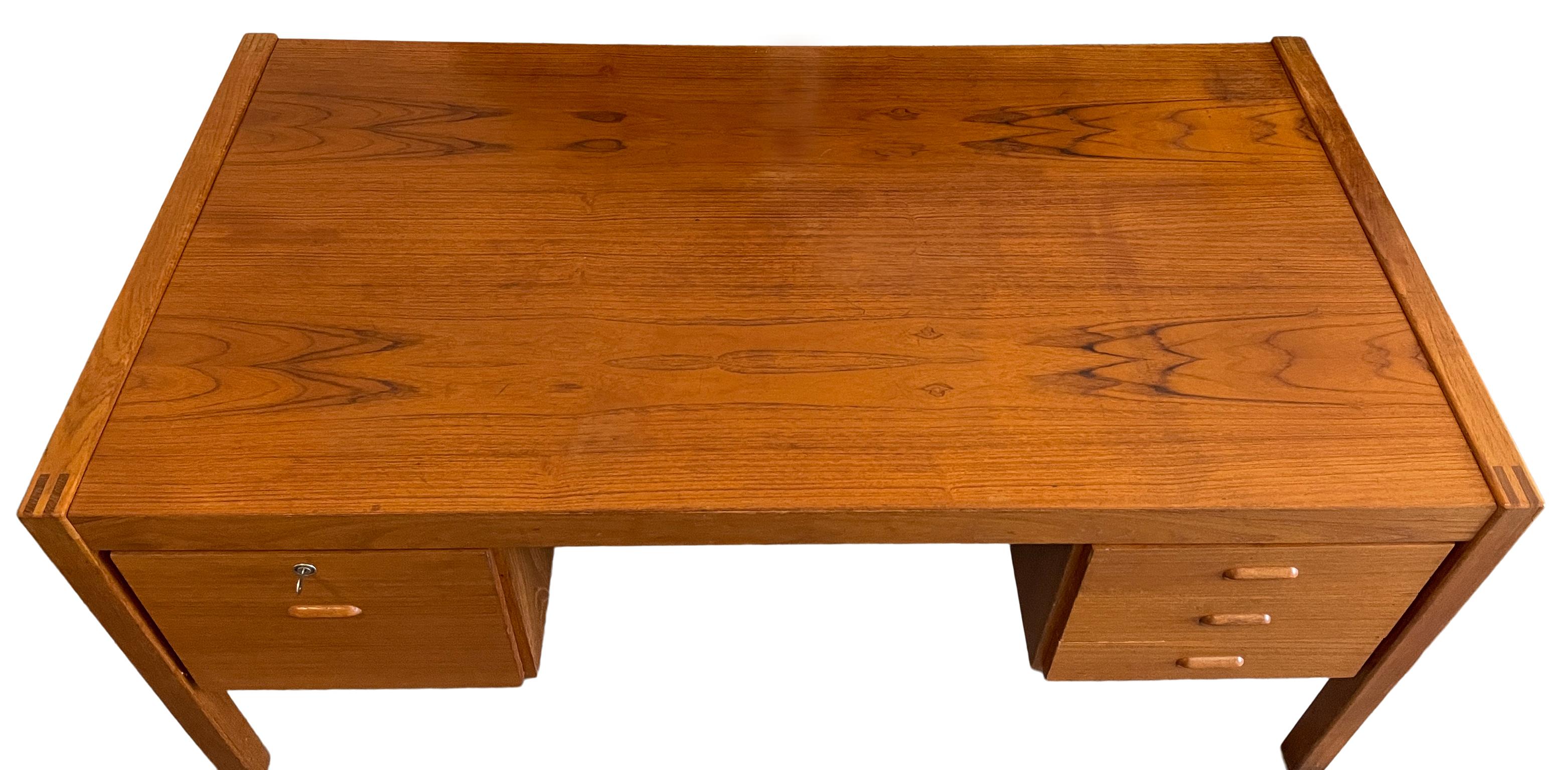 Mid century Danish modern teak knee hole 4 drawer desk with key. Beautiful wood grain on top great construction details - solid wood handles. Made in Denmark.