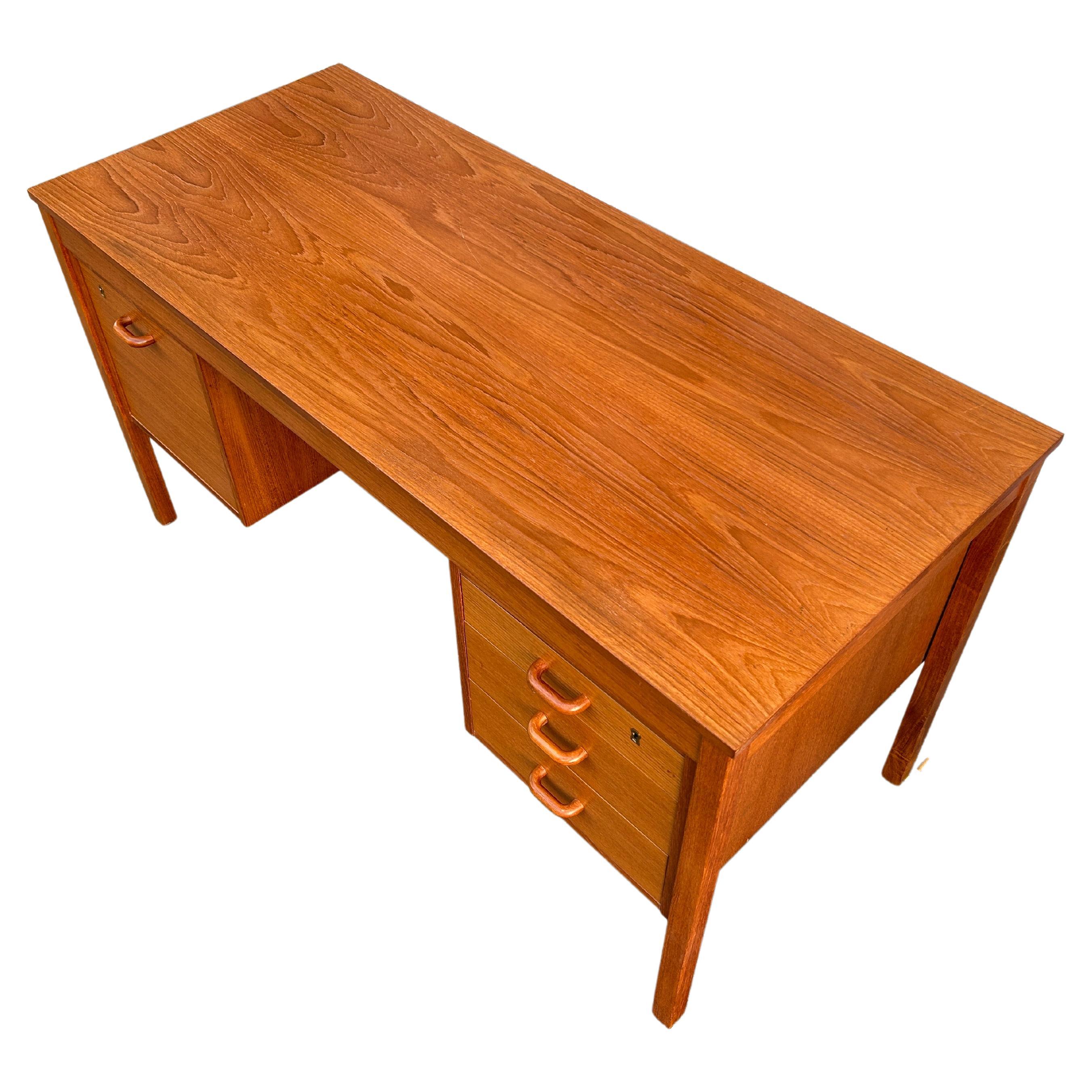 Mid century Danish modern teak knee hole 4 drawer desk with key. Beautiful wood grain on top great construction details - solid wood handles. Made in Denmark.

Dimensions: H: 28.5 inches: W: 53 inches: D: 23 inches.