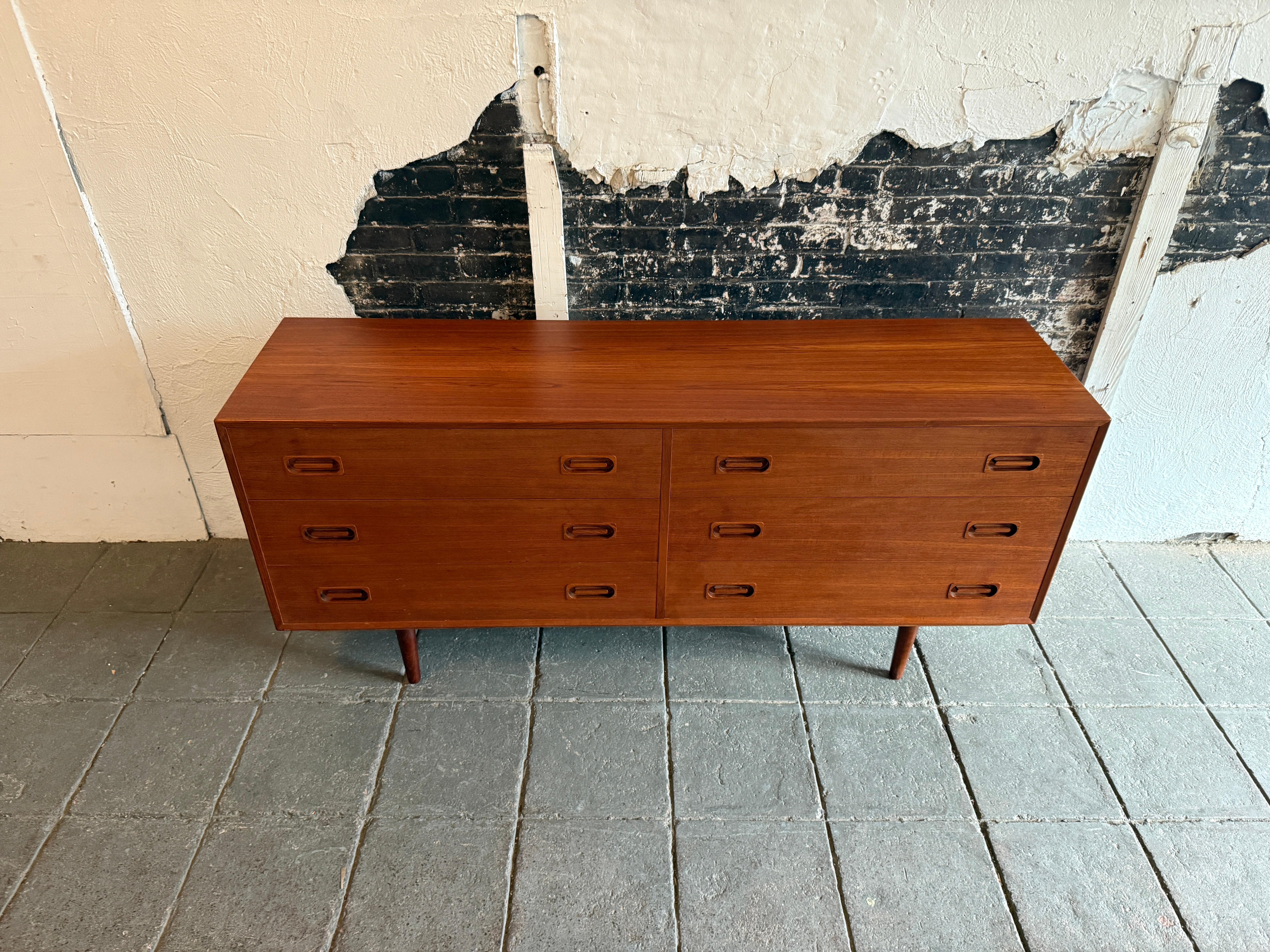 Very clean mid-century Danish modern long and low teak 6 drawer credenza or dresser. All drawers slide smooth with unique inset handle / pulls solid teak. Beautiful teak grain. Very clean inside and out with solid blonde birch drawer construction