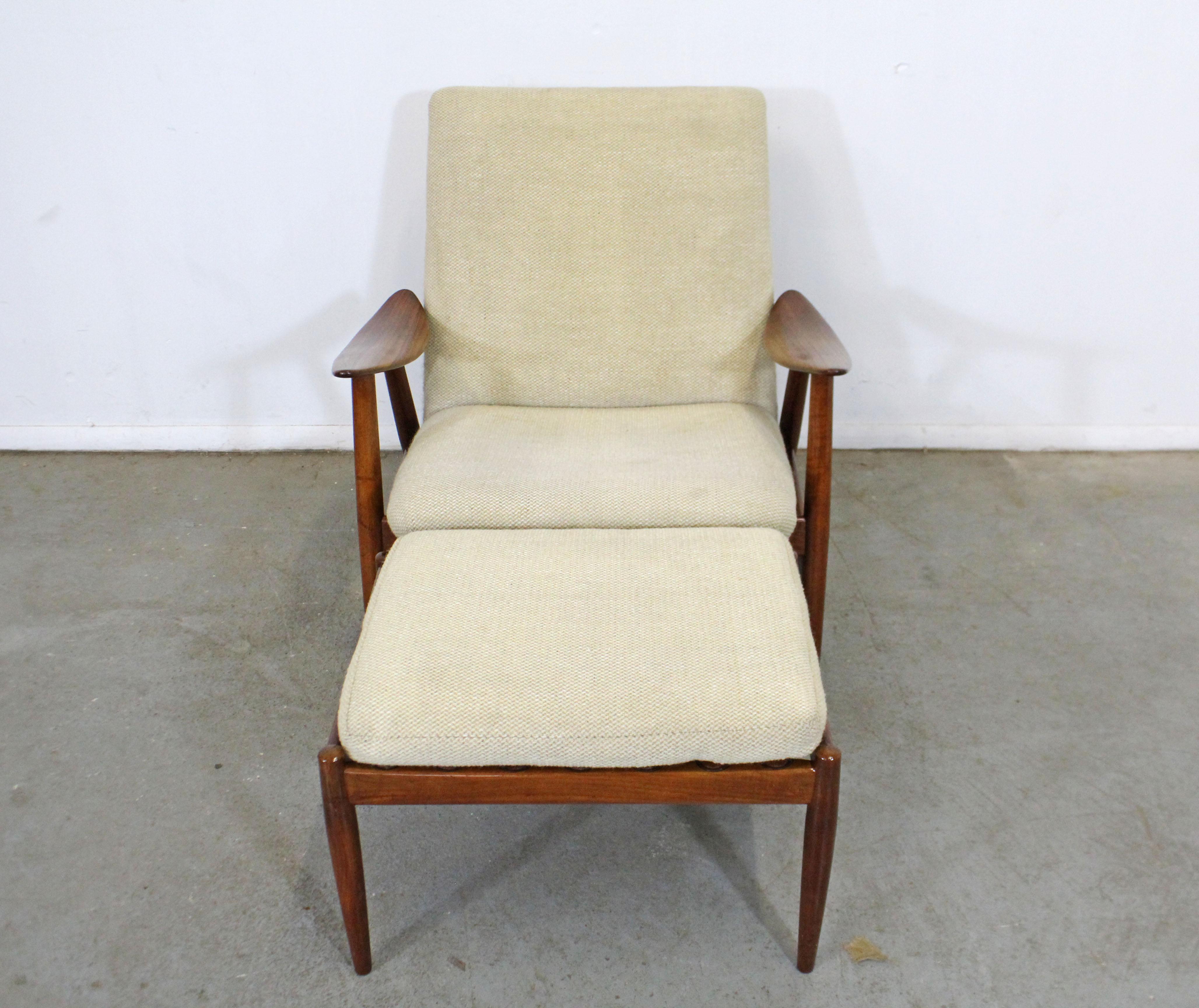 What a find. Offered is a vintage Danish modern lounge chair and ottoman with teak bases. Features uniquely sculpted arms and legs. In good condition with slight surface scratches and faint stains on the fabric. It is structurally sound. It's not