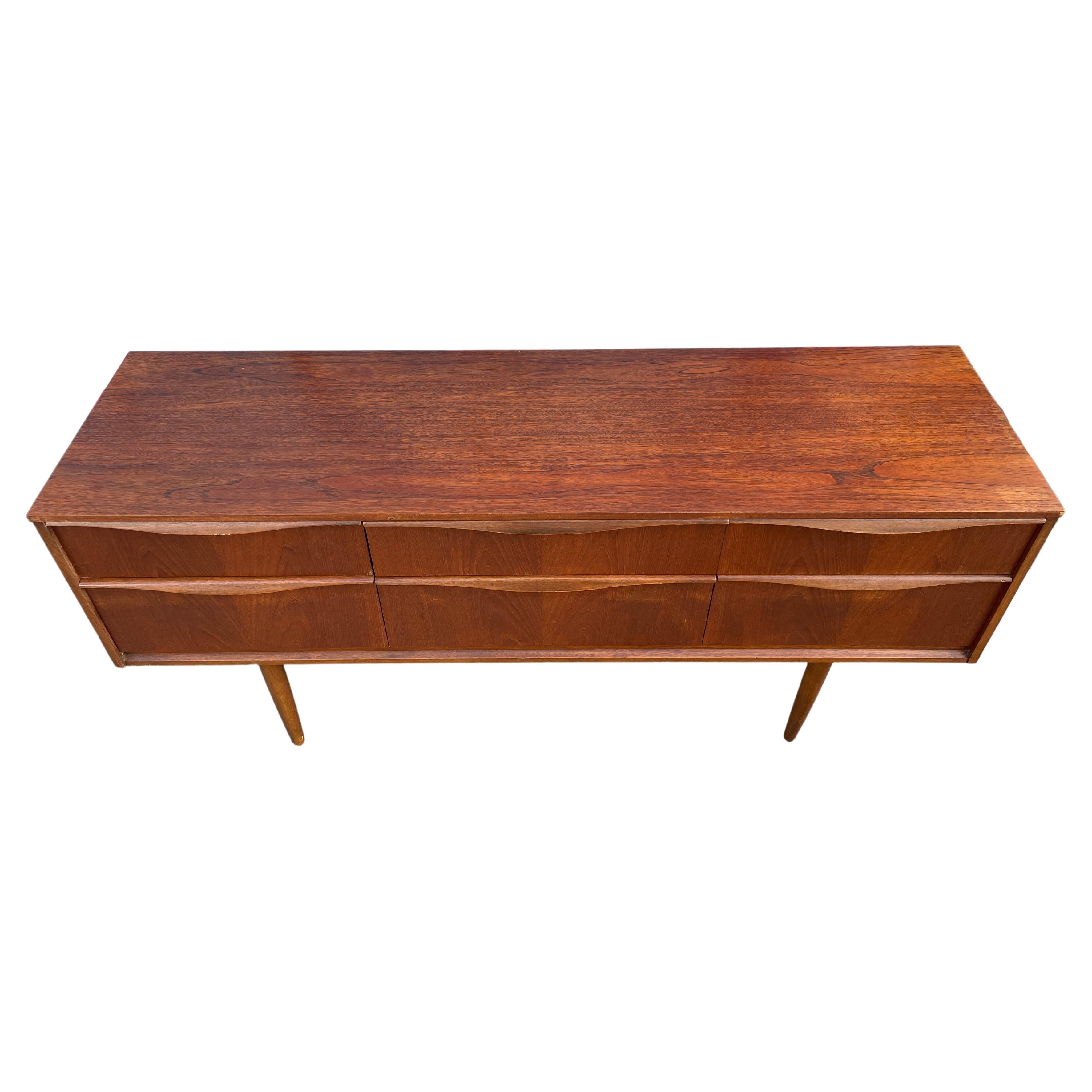 Mid century Scandinavian modern teak low 6 drawer credenza dresser. Beautiful simple designed Low Dresser or Credenza in the style of Børge Mogensen - dark teak wood with sculpted handles. Sits high on 4 tapered teak legs. Clean inside and out. Made